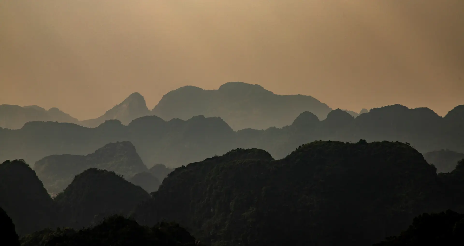 Layered ridgelines fading into evening haze
