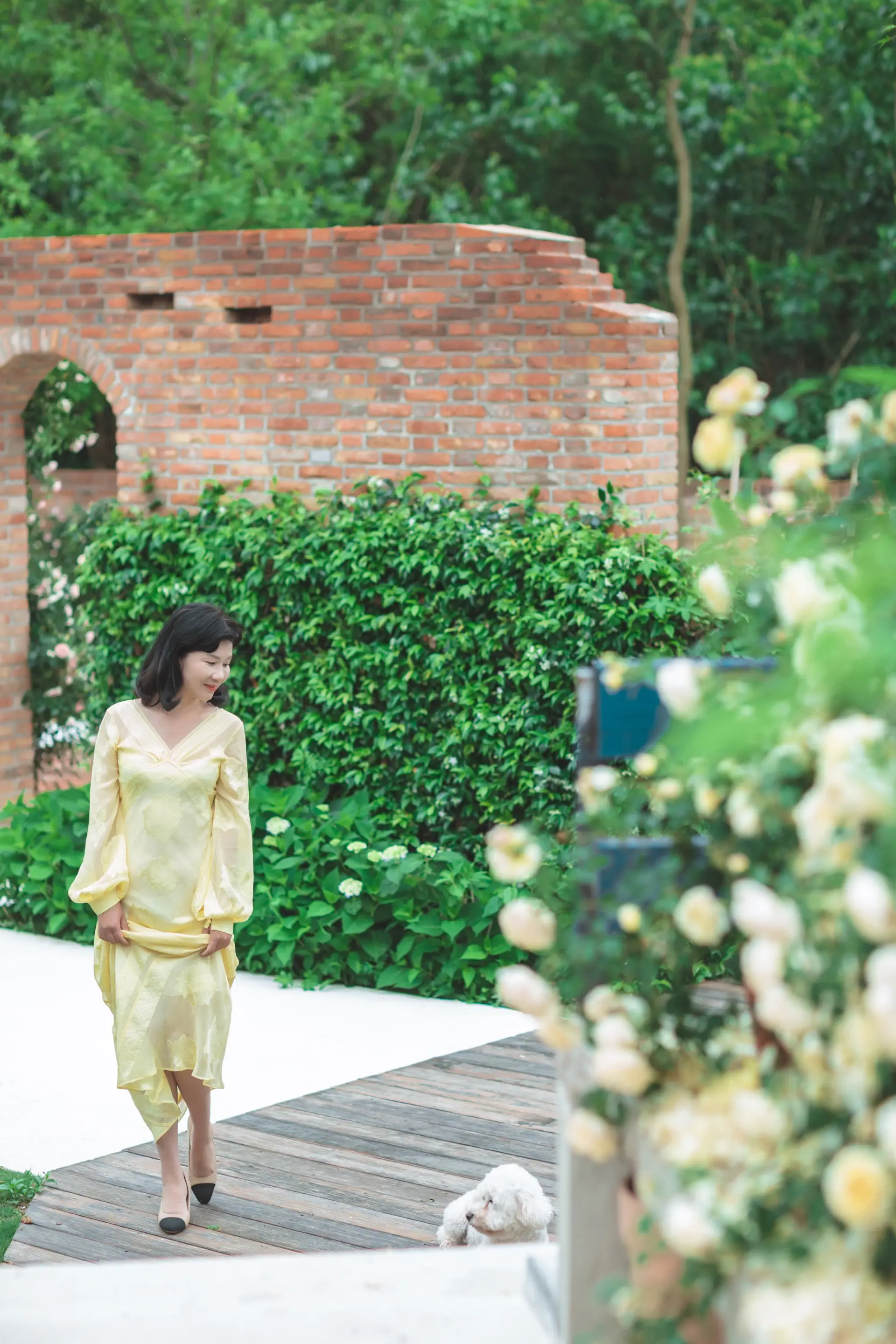 A bride walking through a rose-filled garden terrace