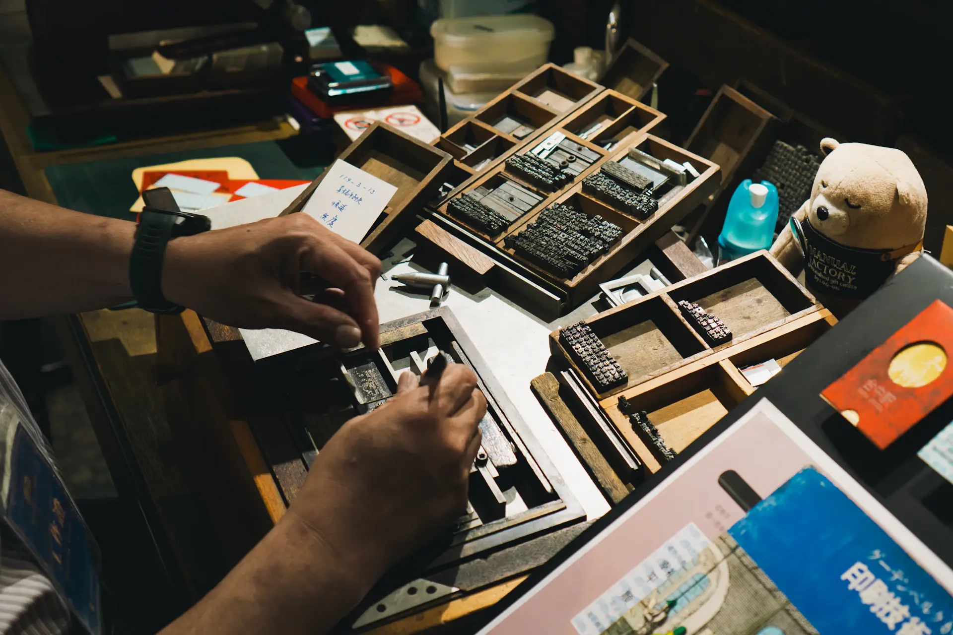 Hands selecting leather and veneer samples laid across a workbench