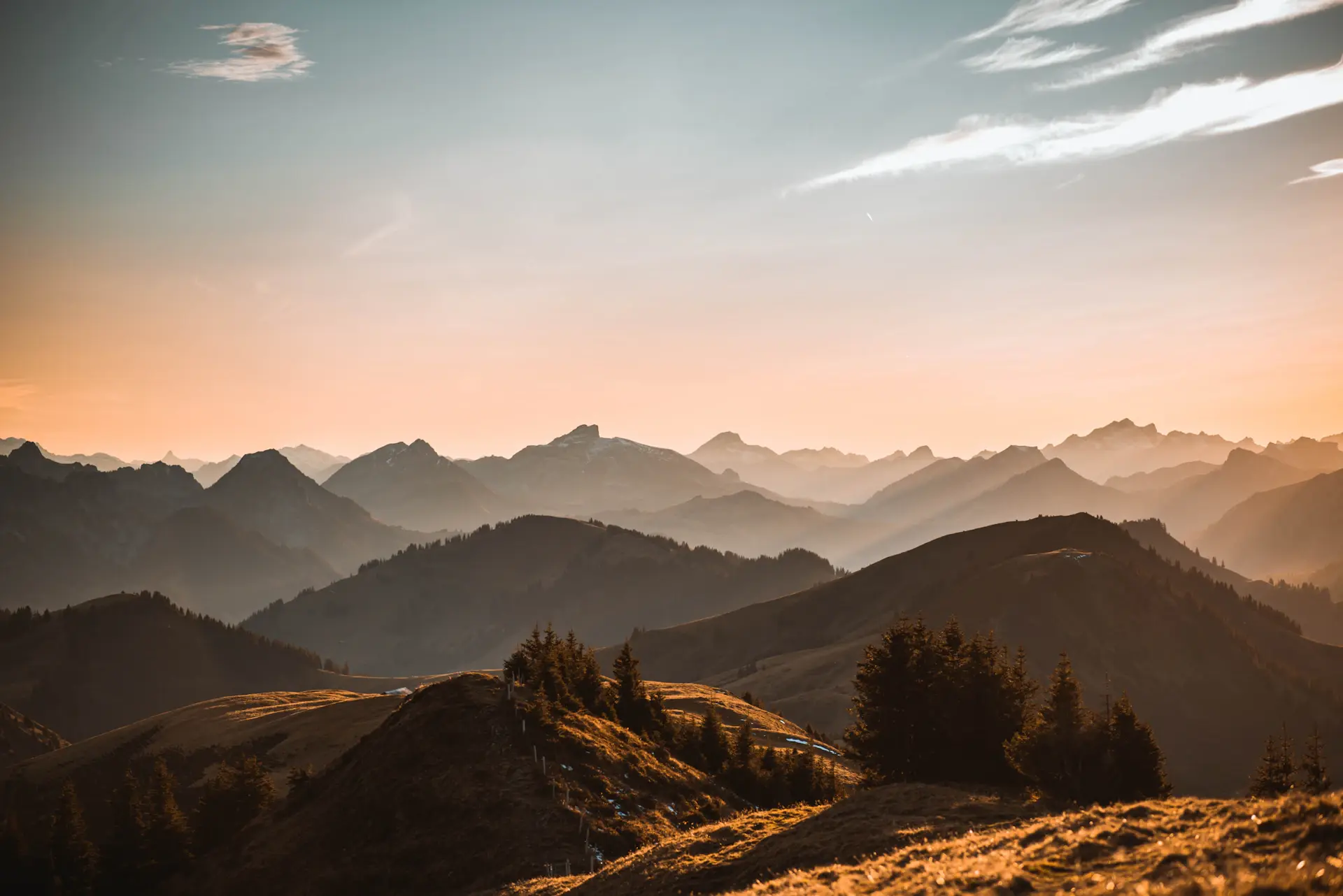 Snow-dusted alpine ridgeline rising above a low sea of cloud at first light