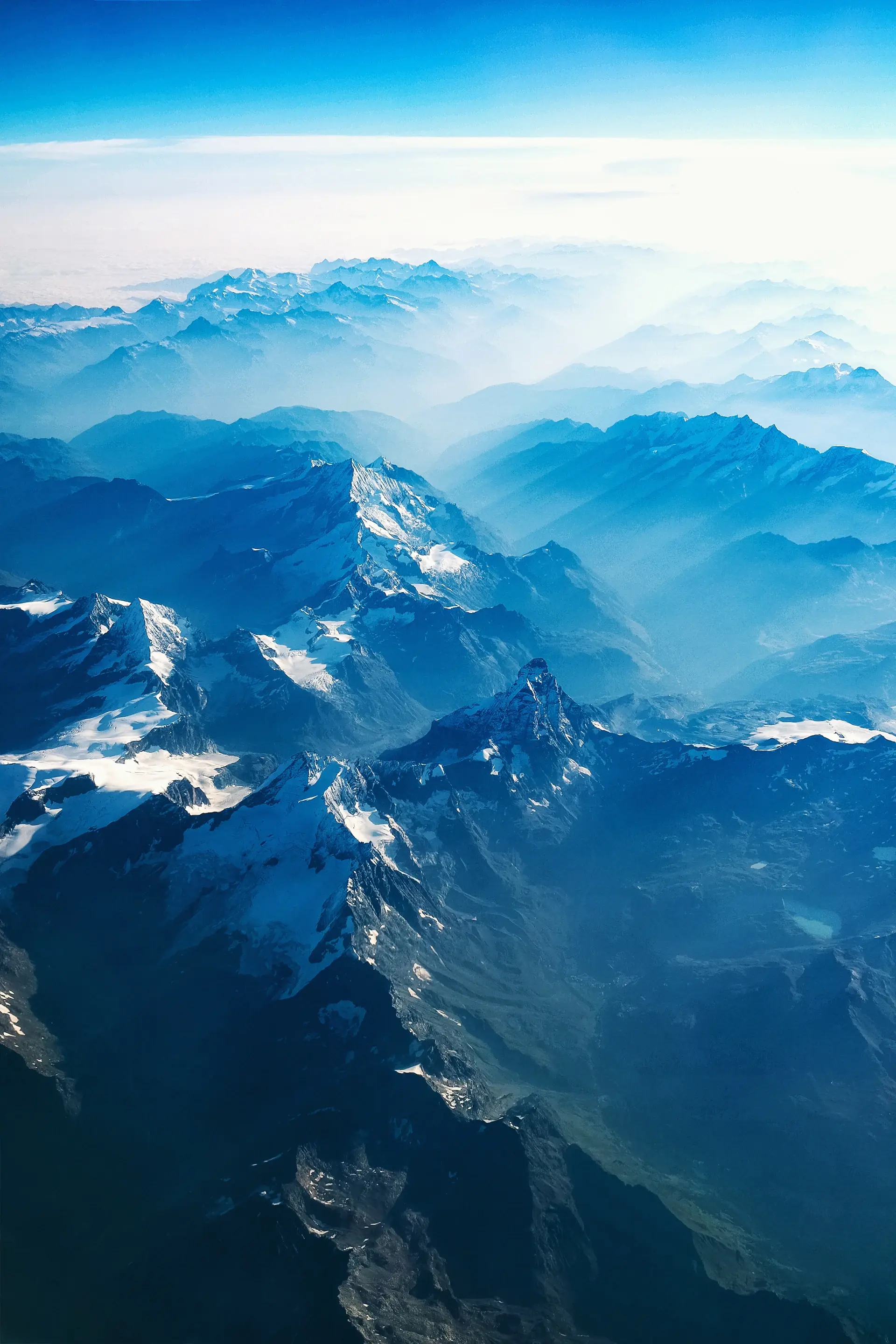 Snow-dusted mountain peaks rising above a sea of cloud