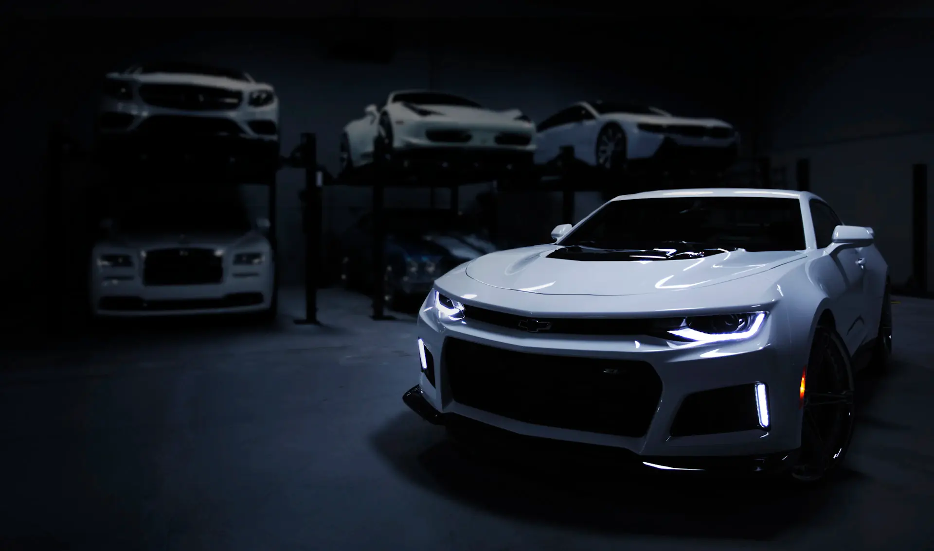 A dimly lit private showroom with a single luxury motorcar