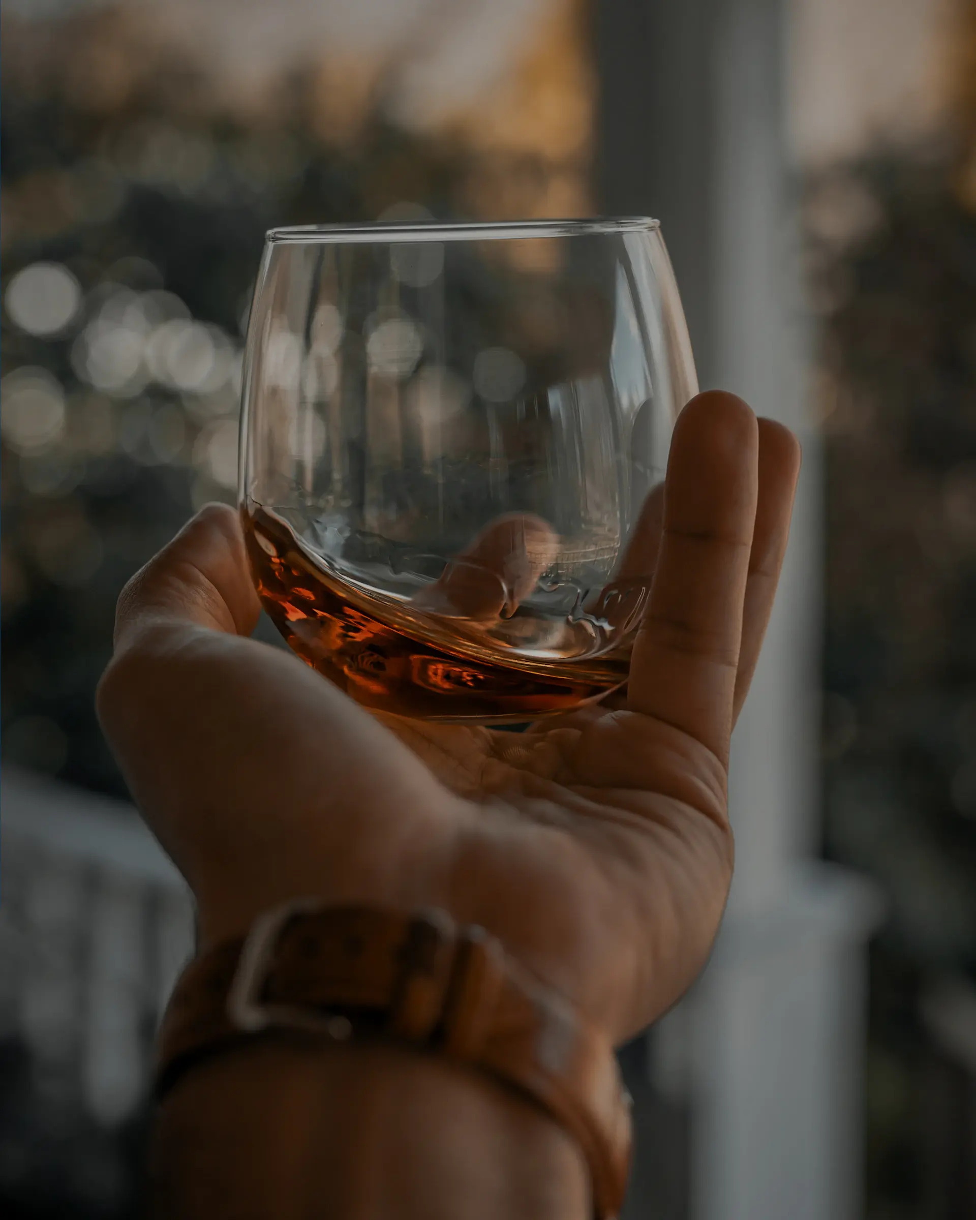 Amber single malt whisky in a crystal glass beside an aged oak cask