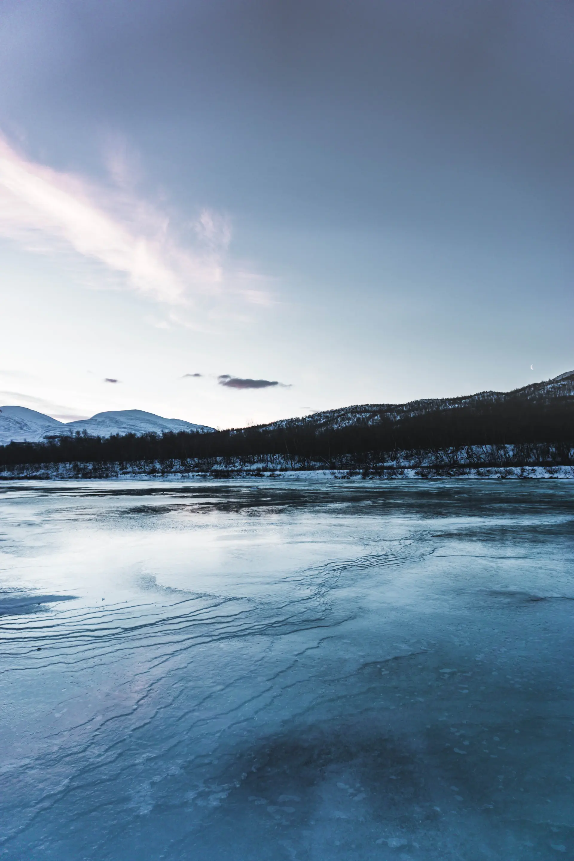 Last evening light glowing across a frozen-edged lake