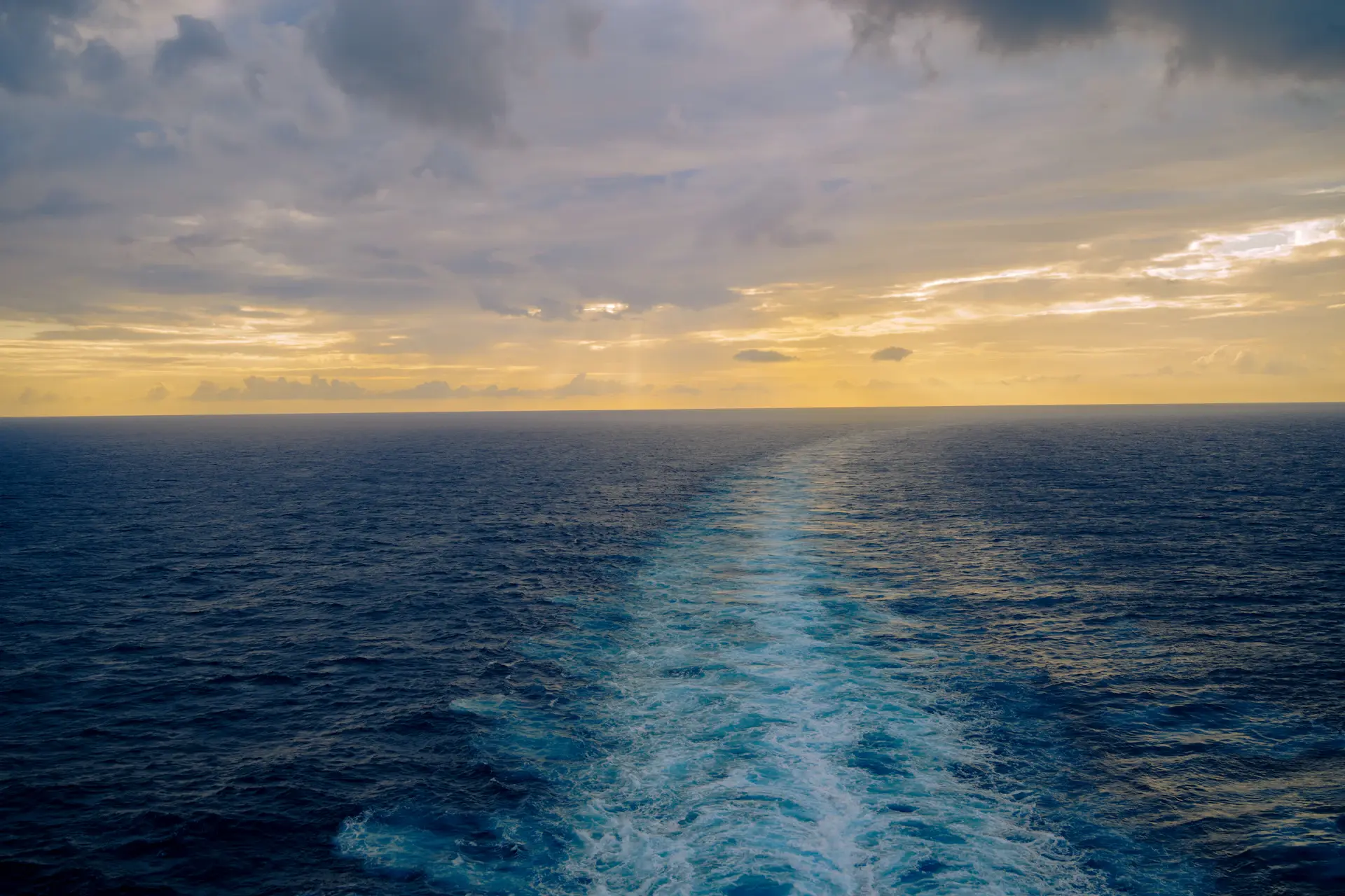 Golden polar light over the ship's wake heading north