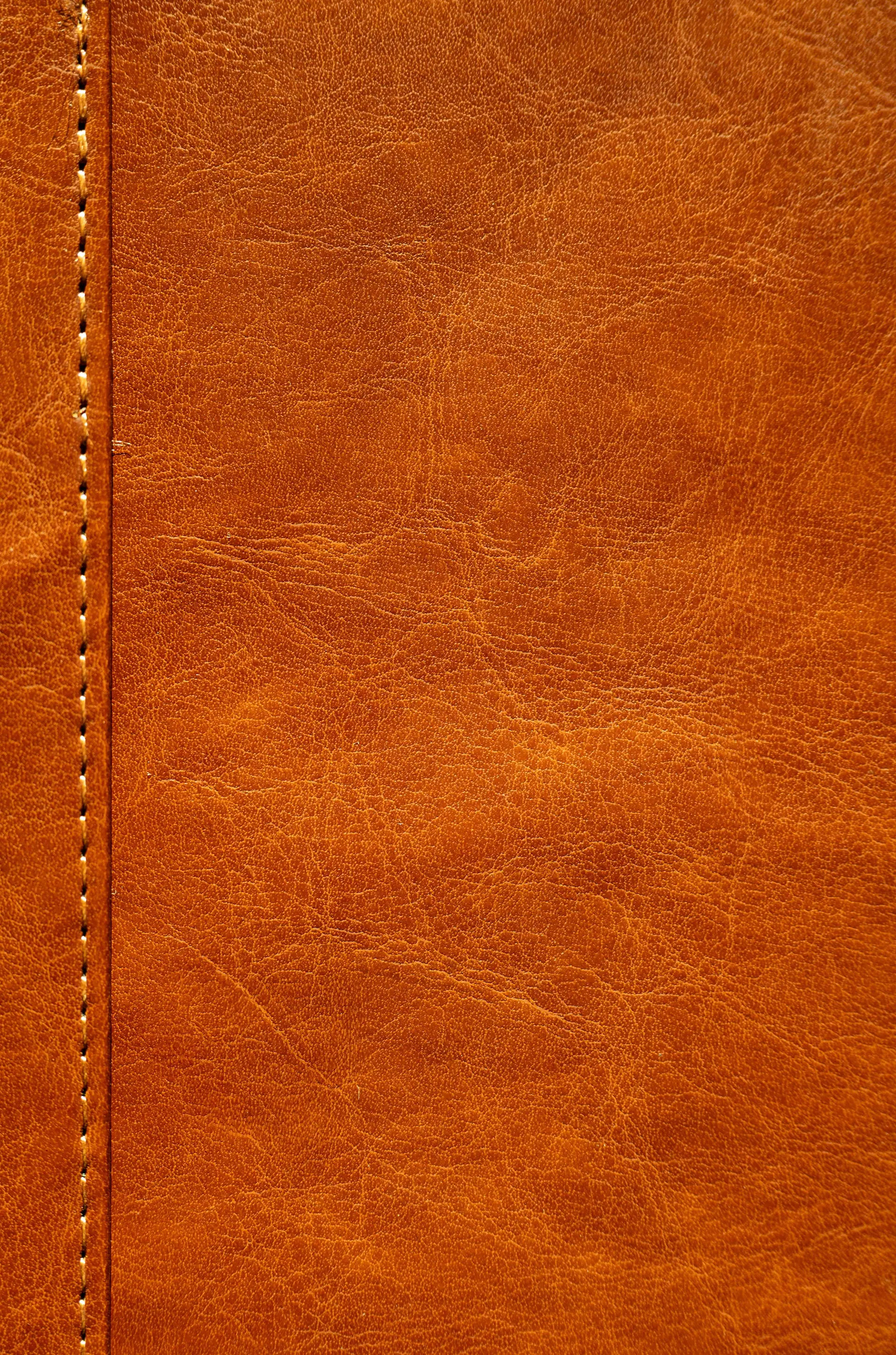 Close detail of hand-stitched leather seam under warm light