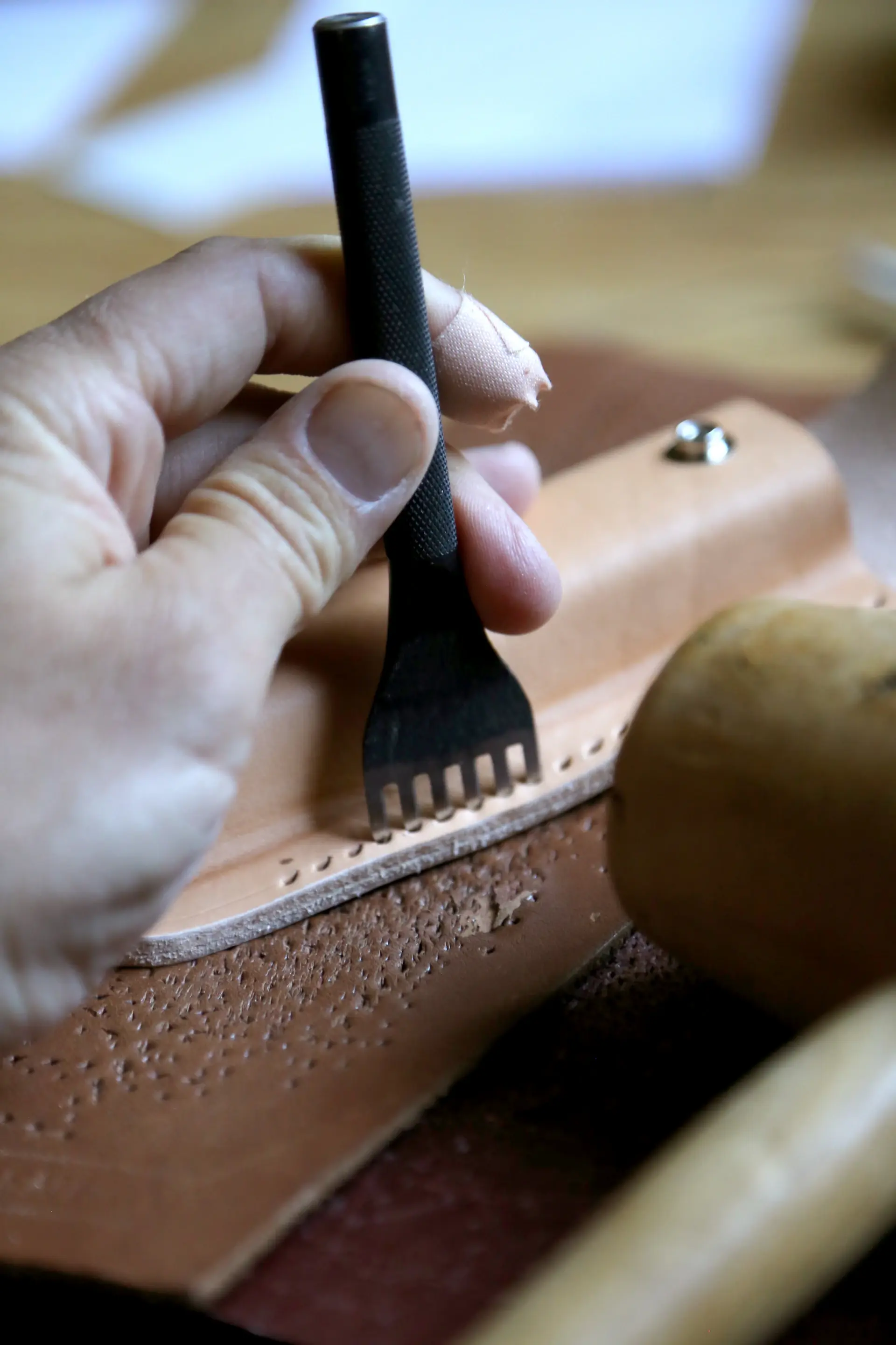 Artisan hand-stitching a leather seat in fine thread
