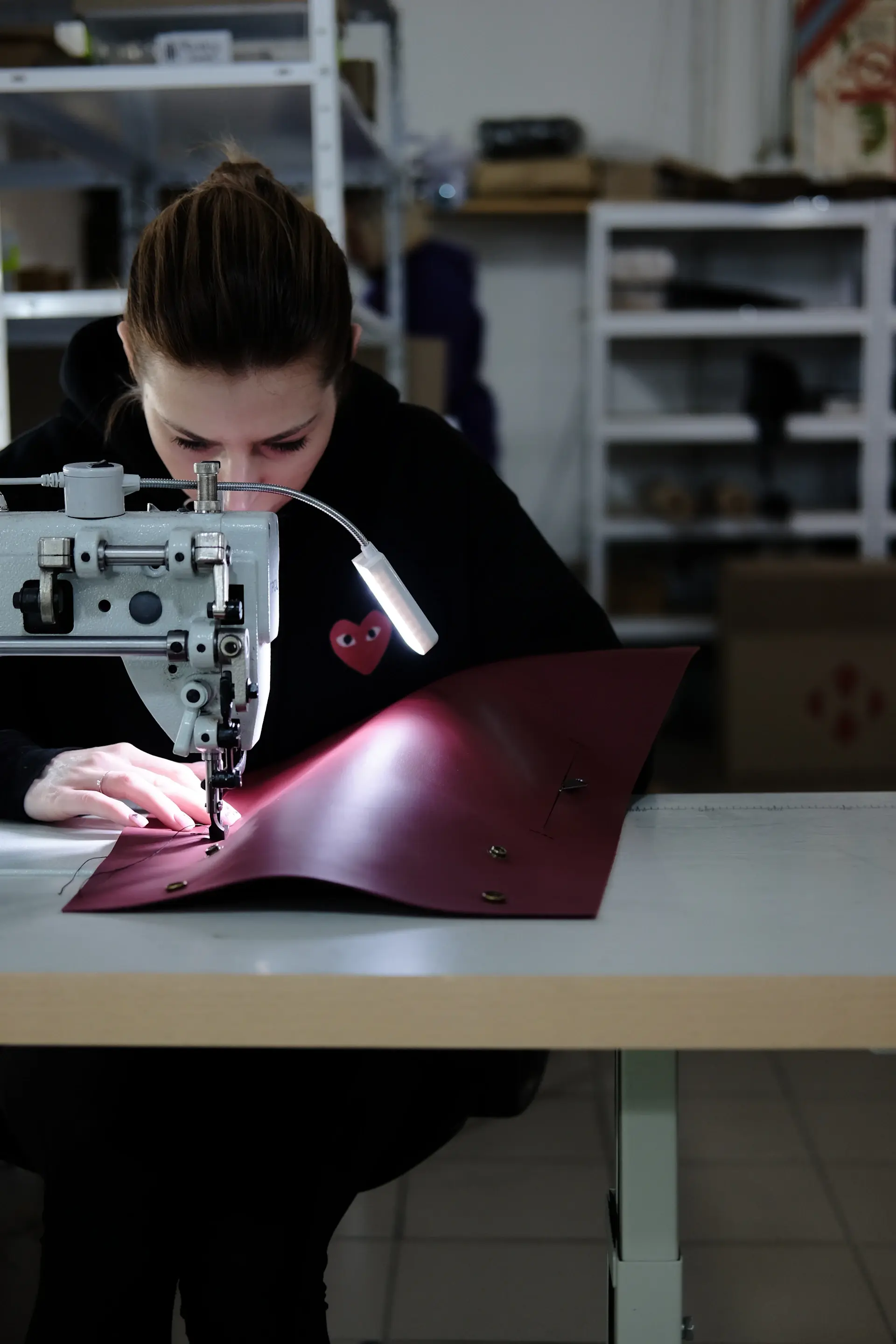 Hands stitching fine leather by hand in a luxury atelier