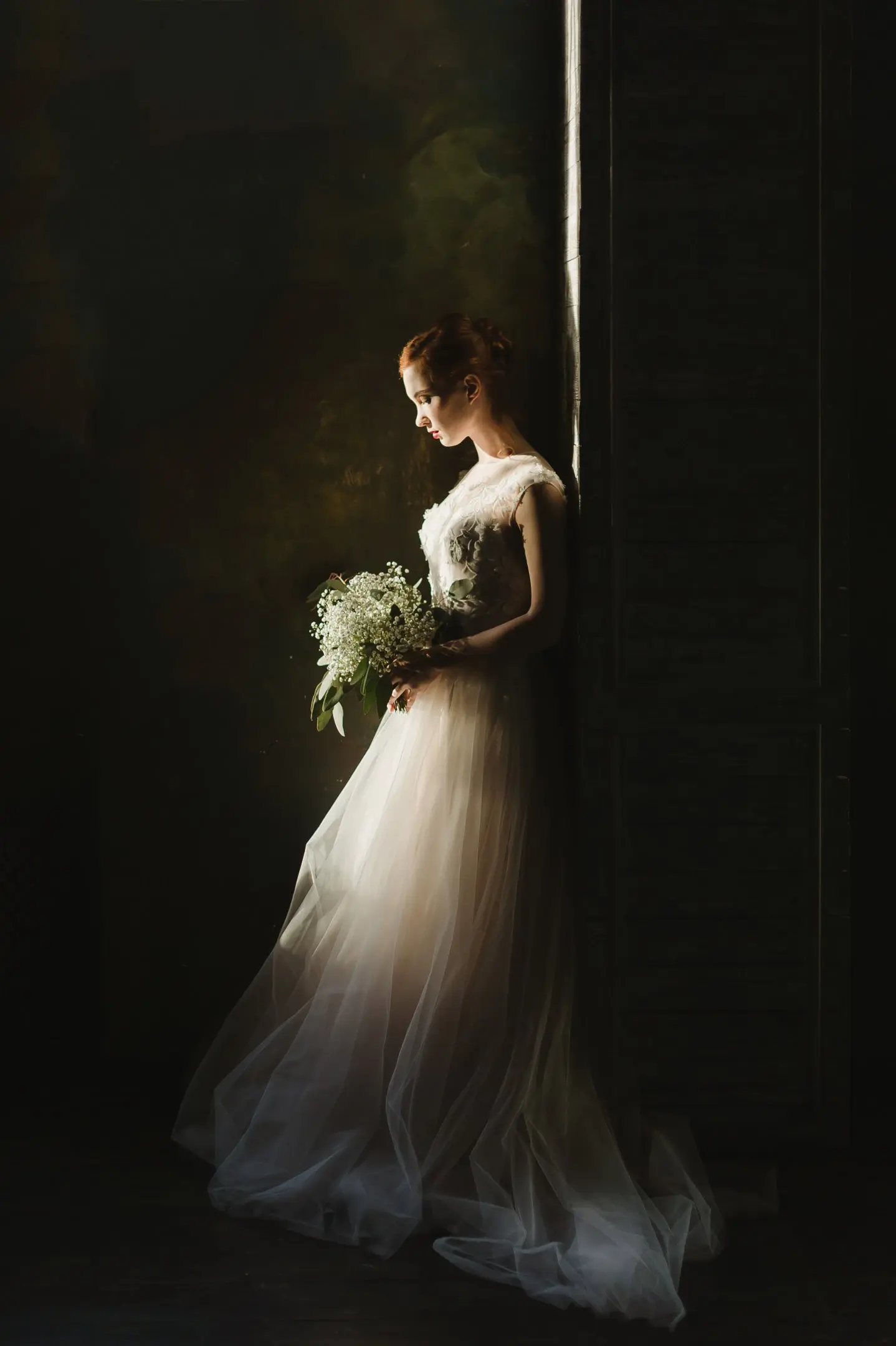 A bride in a soft ivory gown looking toward her partner