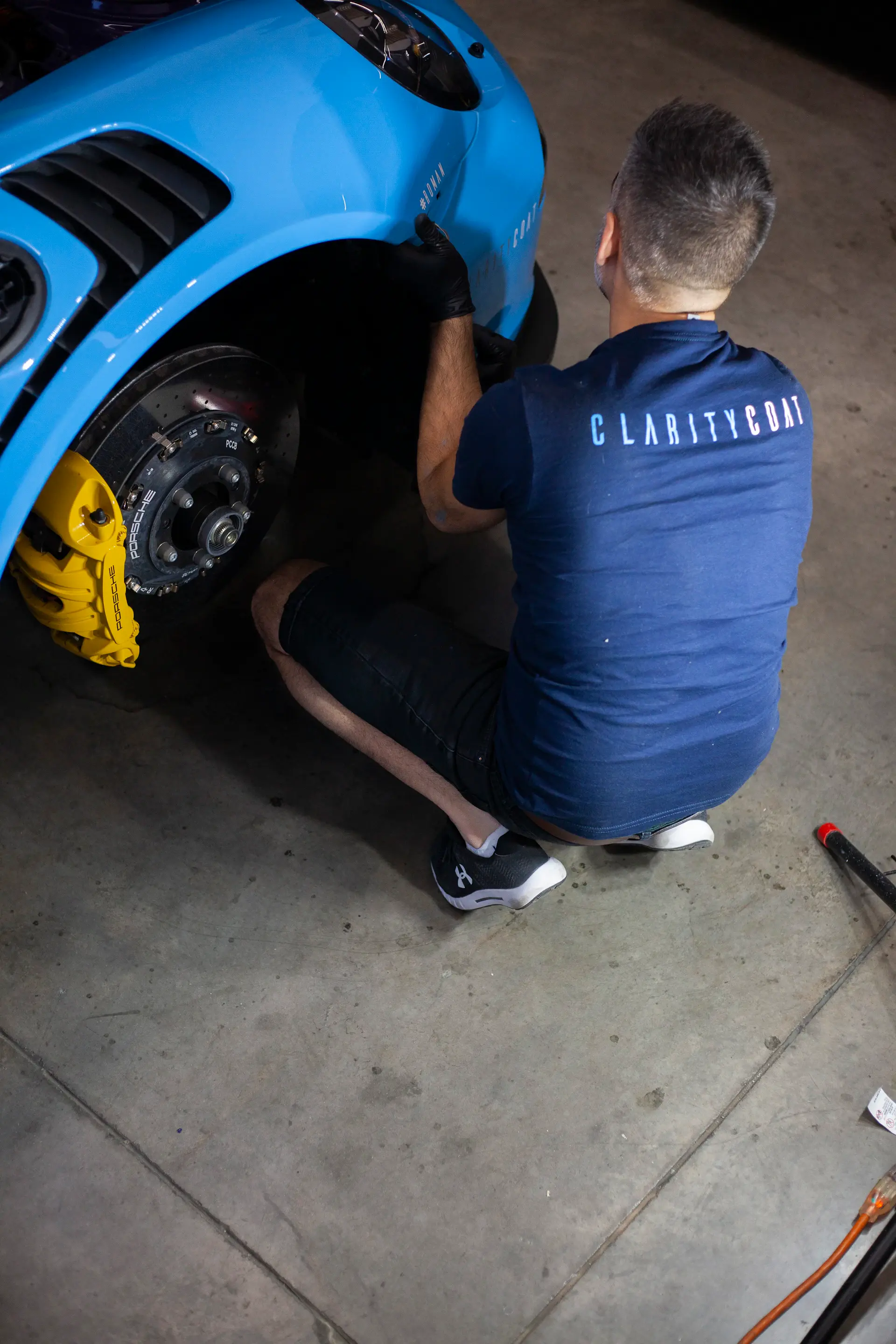 Craftsman aligning a hand-formed body panel on a luxury car