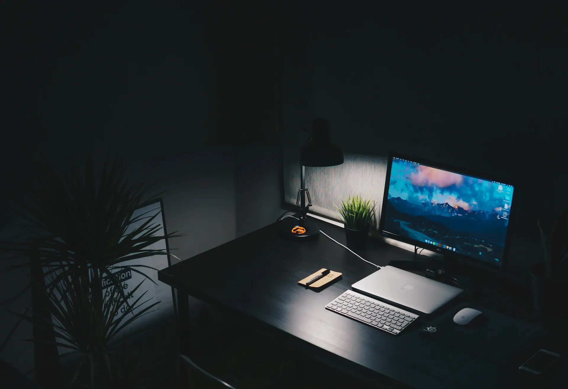 Minimal developer desk setup lit by a single warm lamp