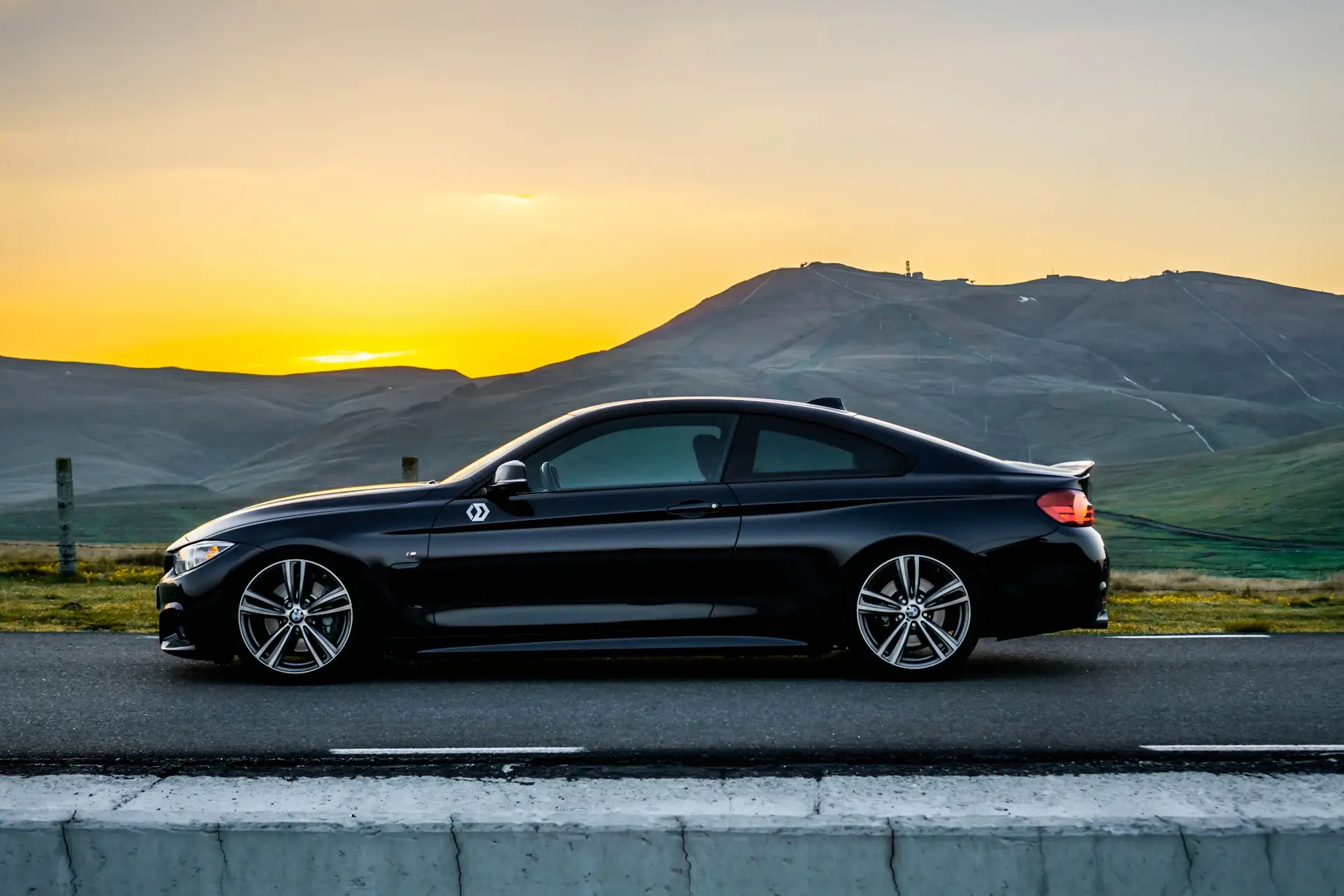A luxury motorcar driving on an open road at dusk