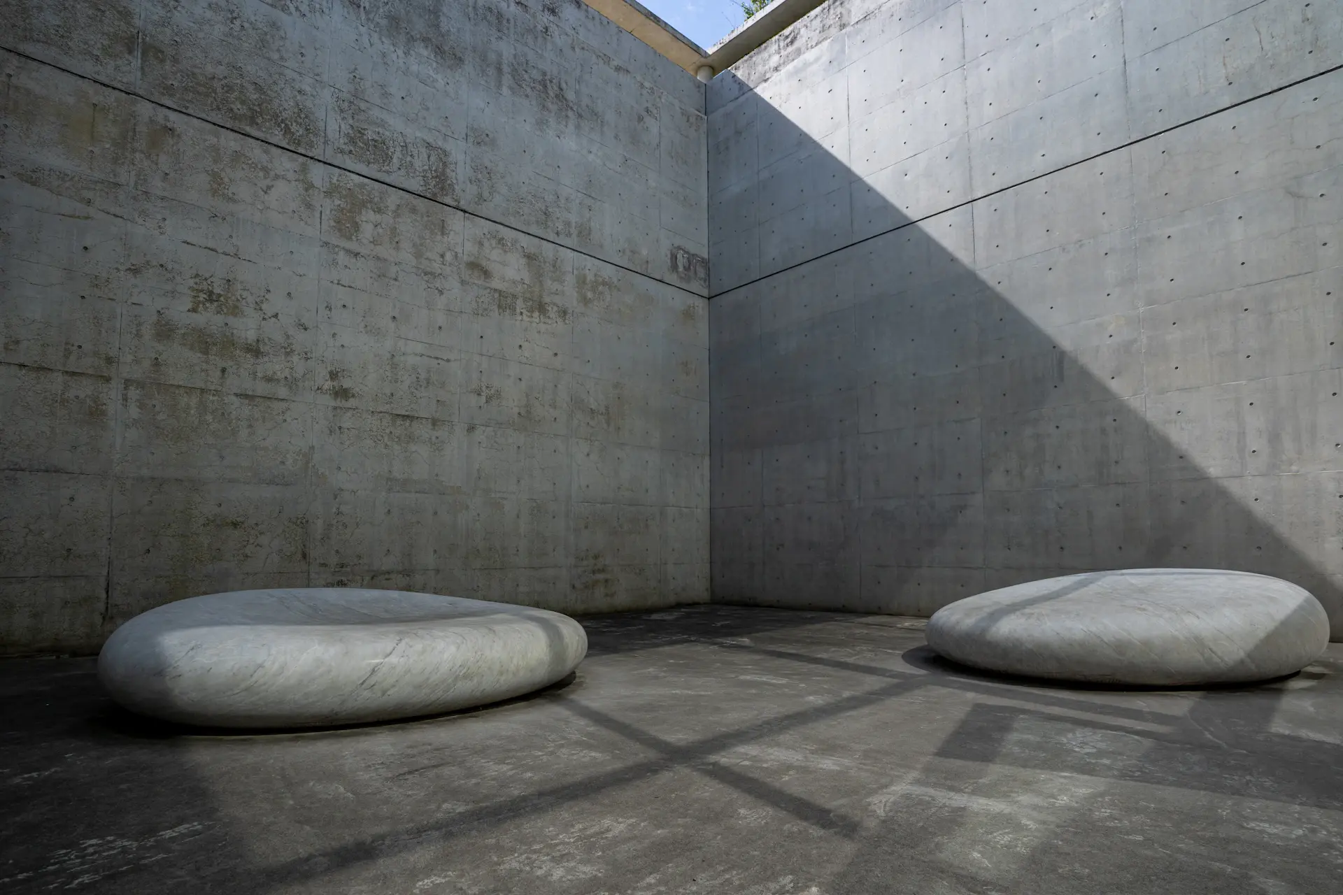 Shaft of daylight across a minimalist stone interior