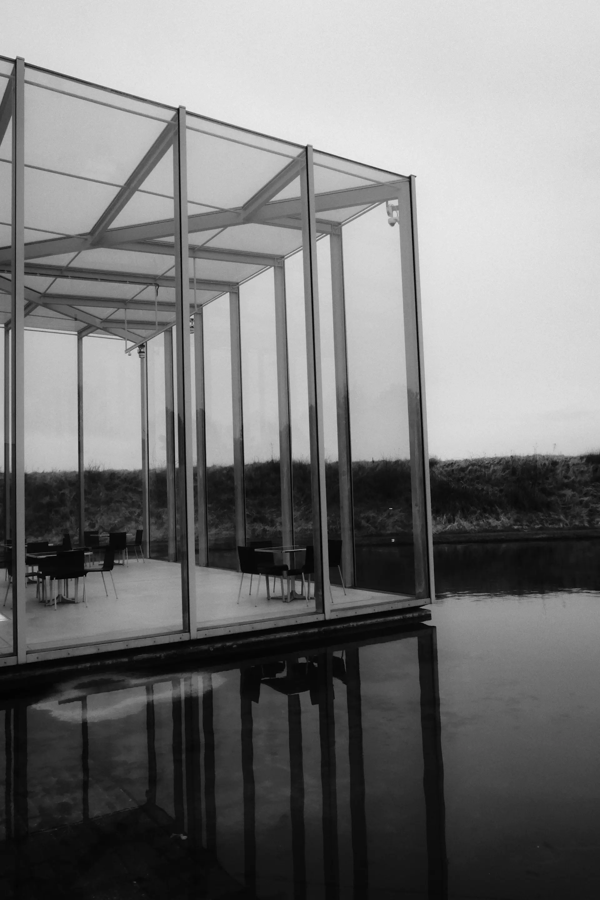 Glass orangery beside a still lake