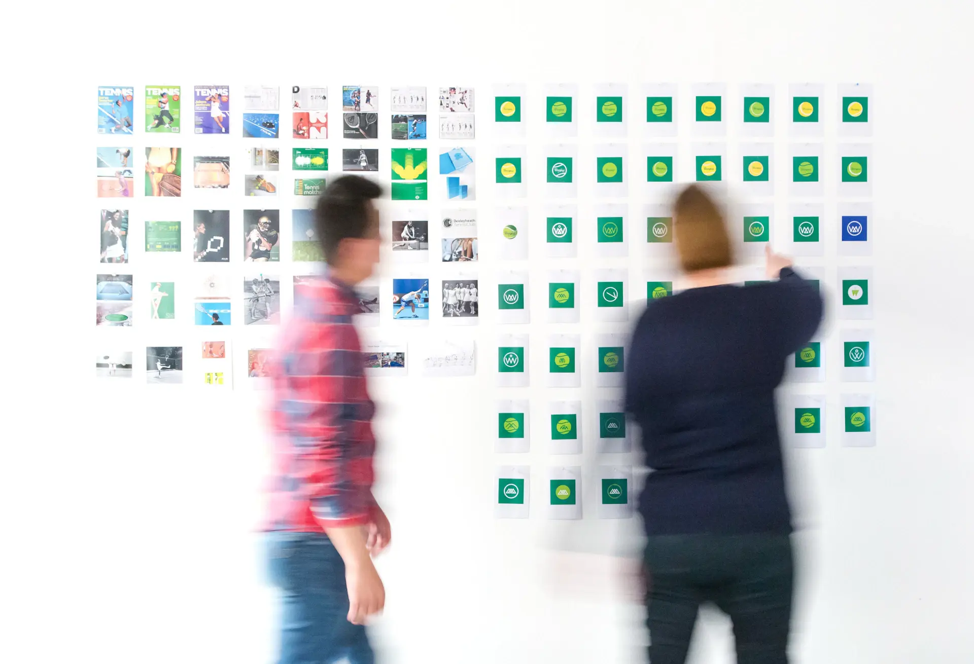 Designer pinning reference photos to a wall