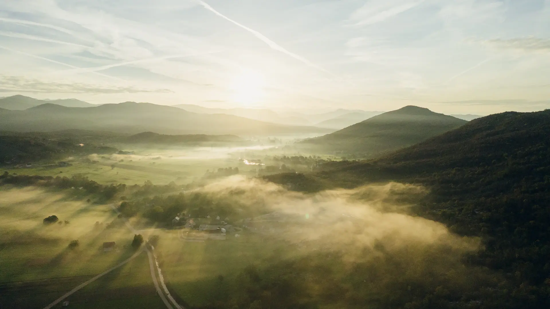 Mist drifting over jagged mountain peaks at first light