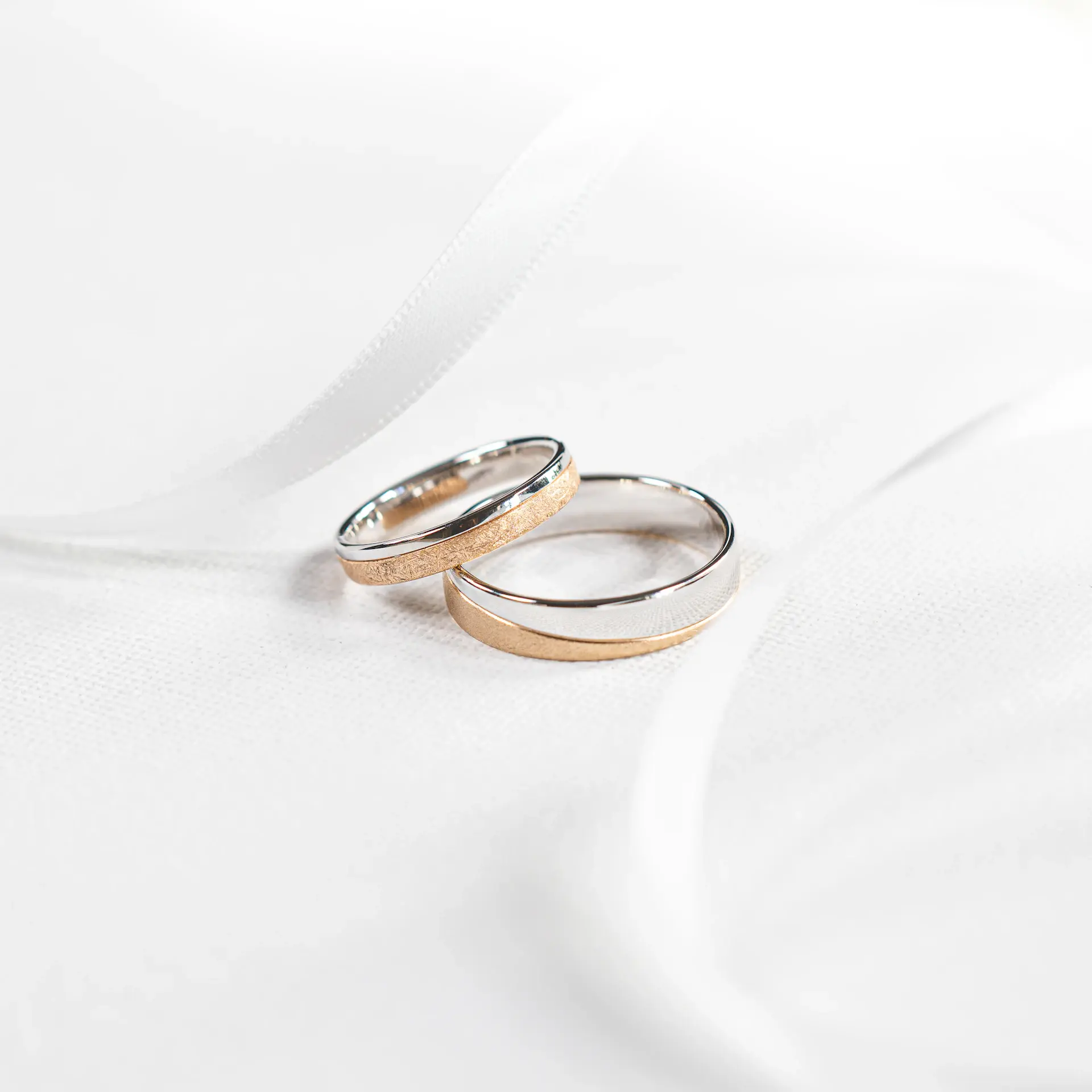 Detail of the wedding rings on white silk