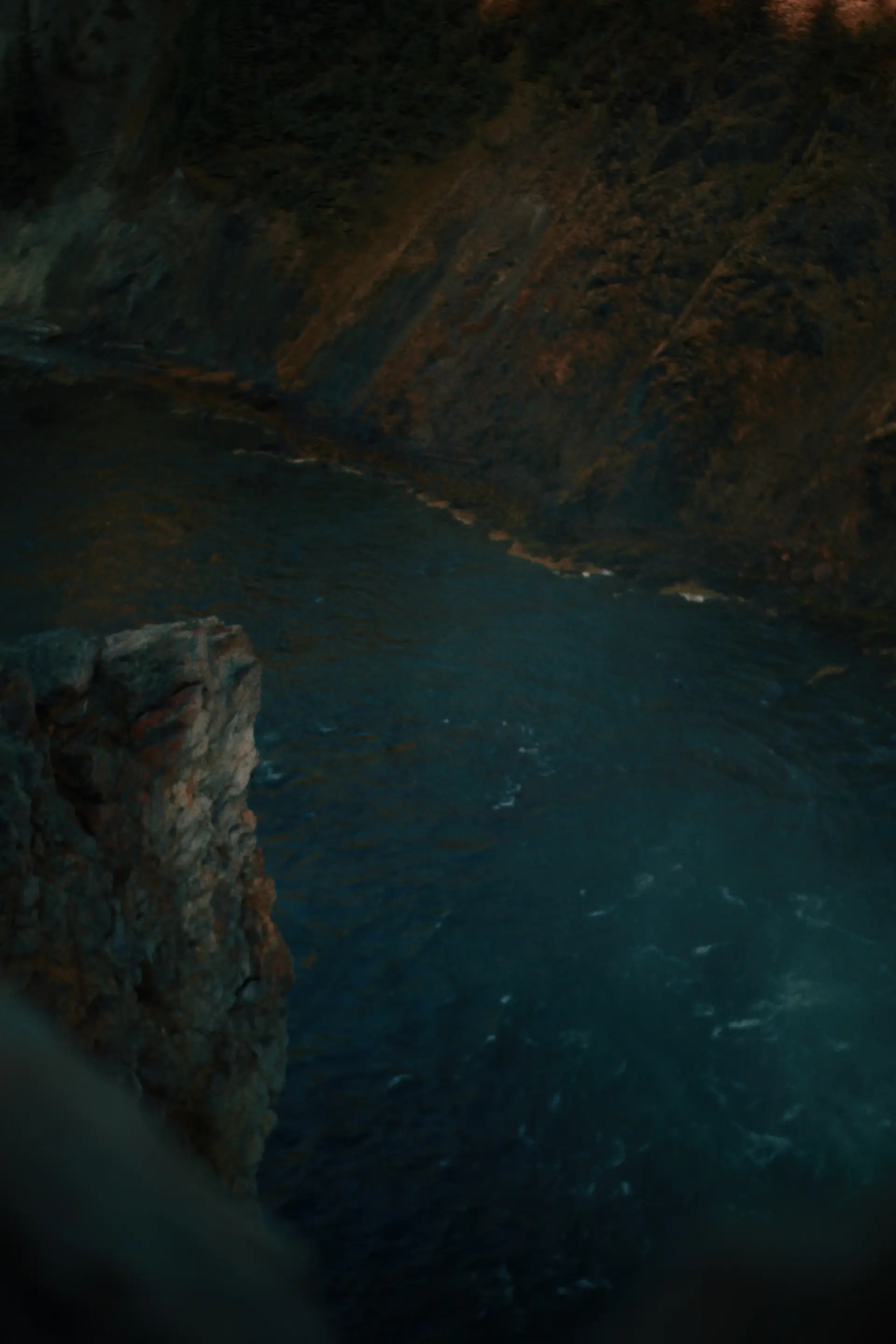 Lone candlelit table on a remote cliff at dusk