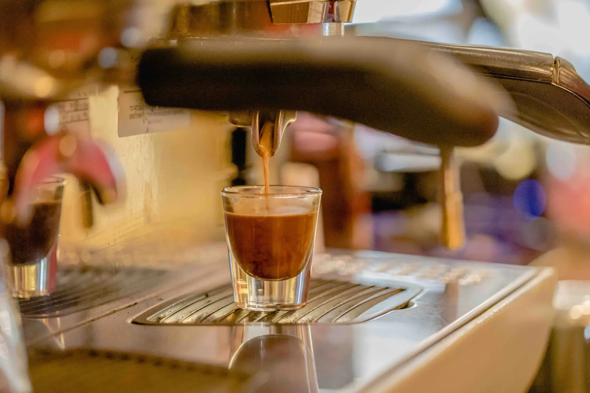 Barista pulling a shot of espresso on a chrome machine