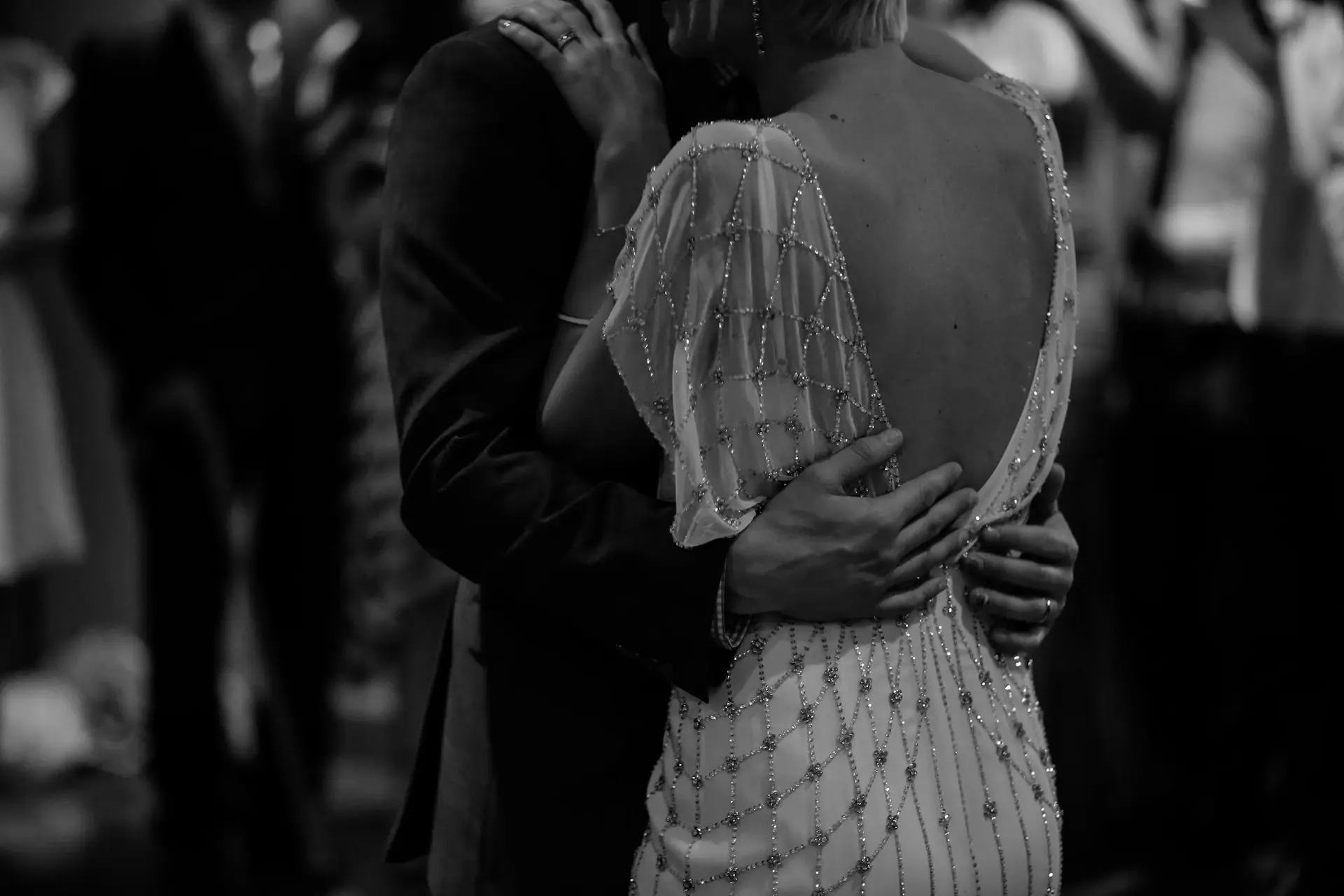 A couple sharing a first dance in a candlelit ballroom