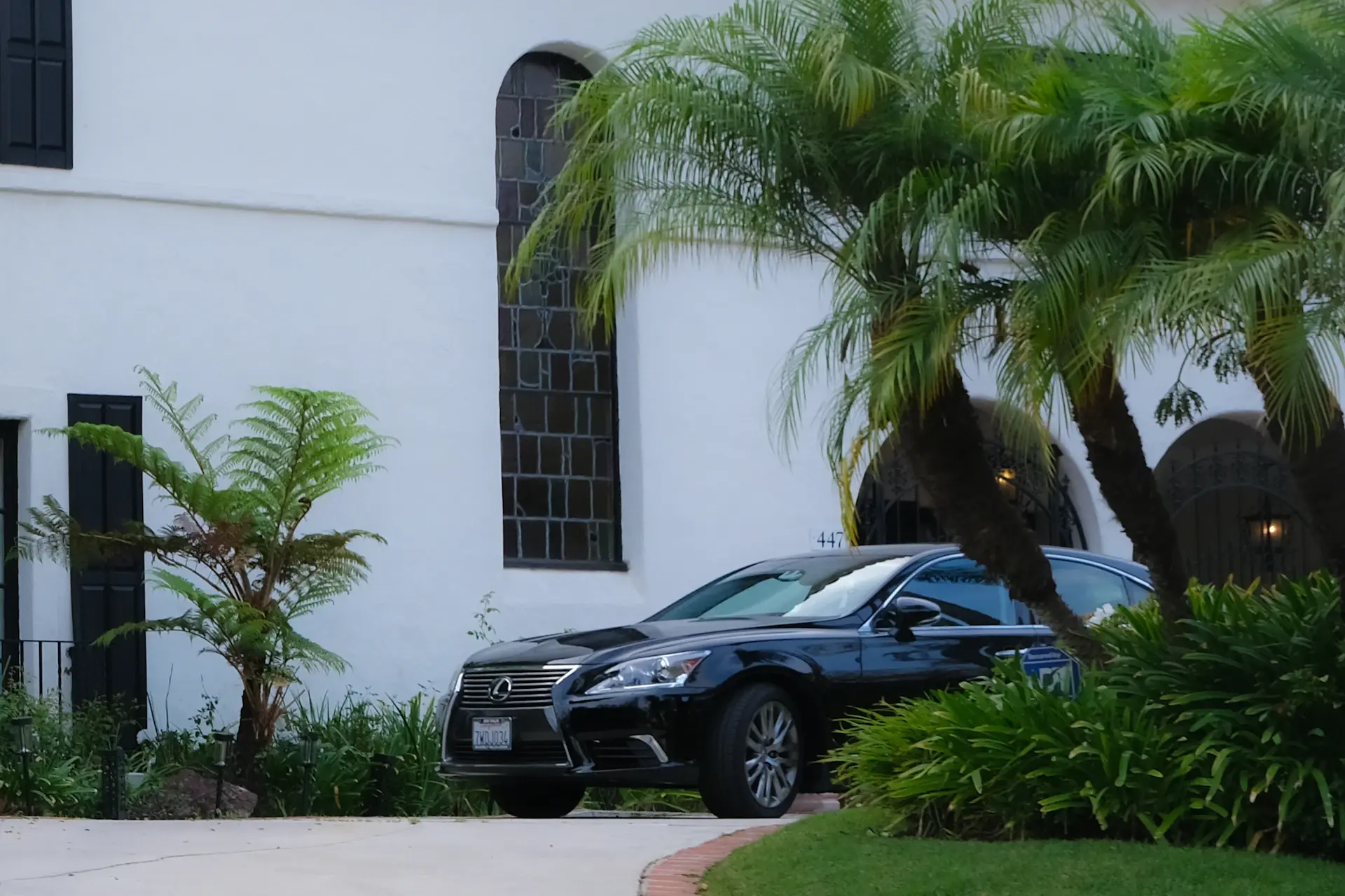 A luxury motorcar arriving at a private residence at night