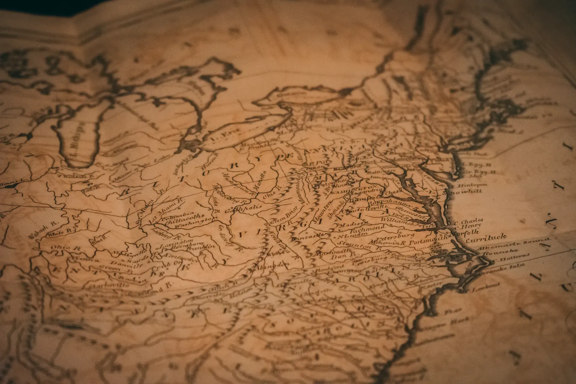 Weathered hands tracing a route across an antique nautical map