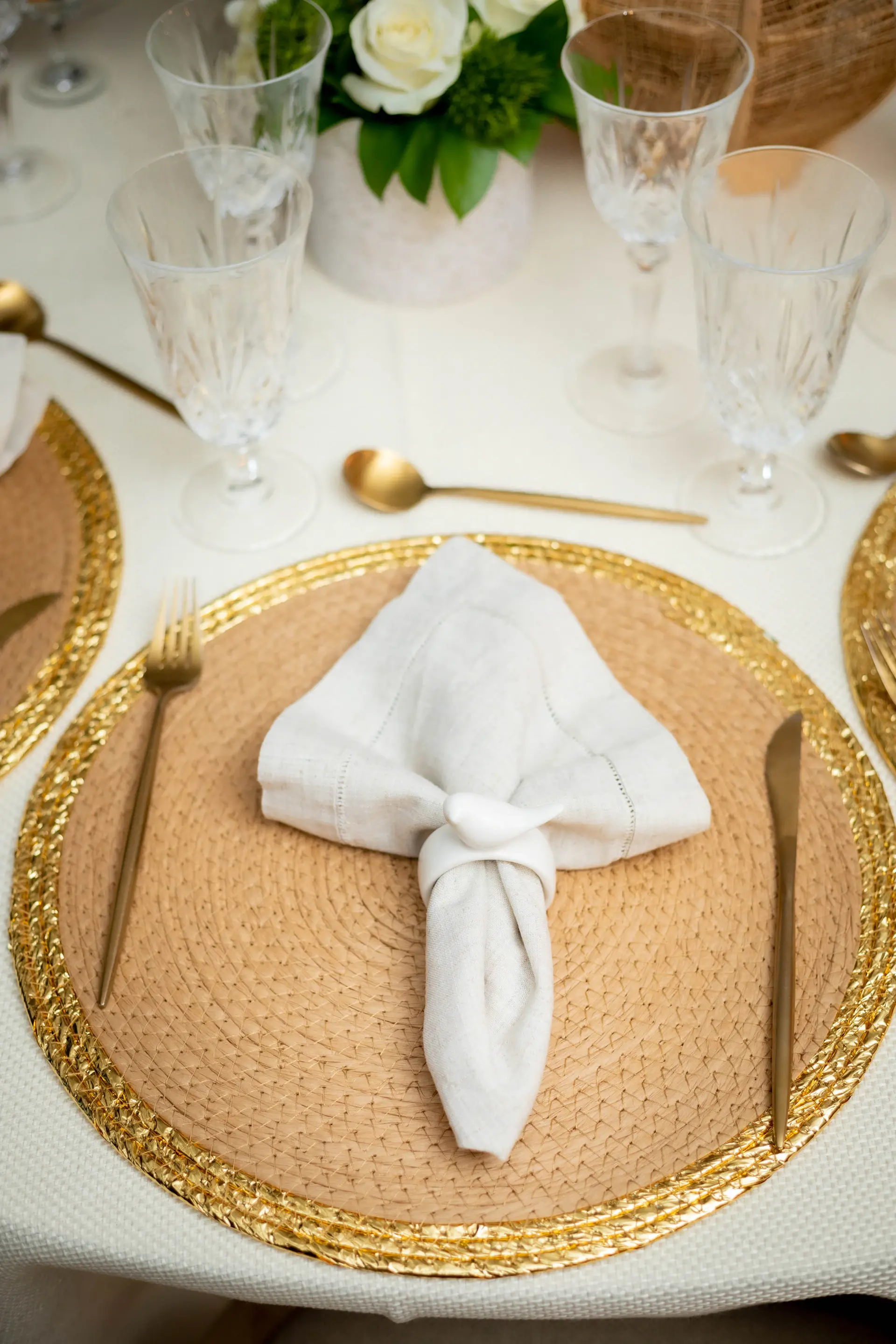 Gold-rimmed place setting on ivory linen