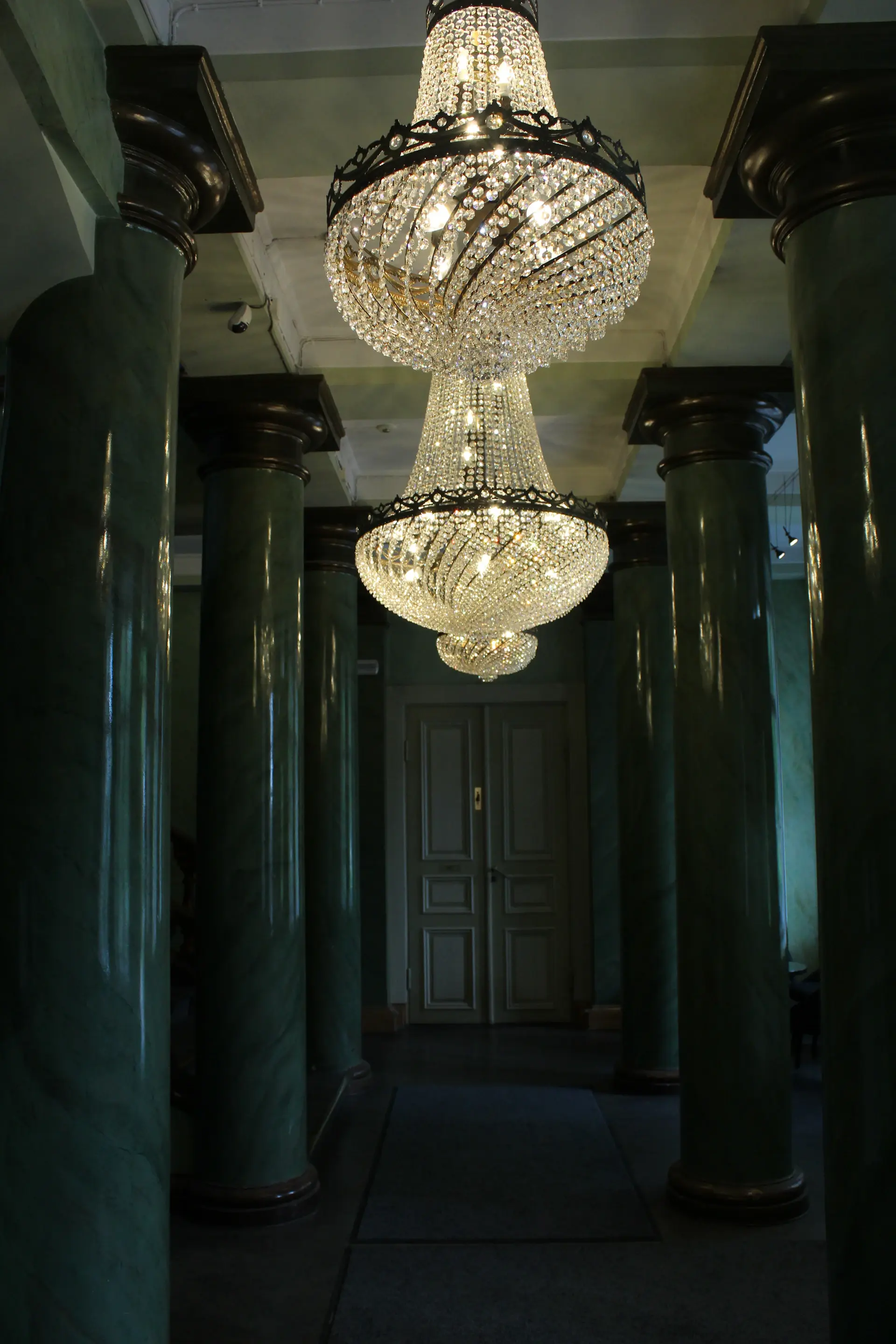 Crystal chandelier glowing above a marble hall