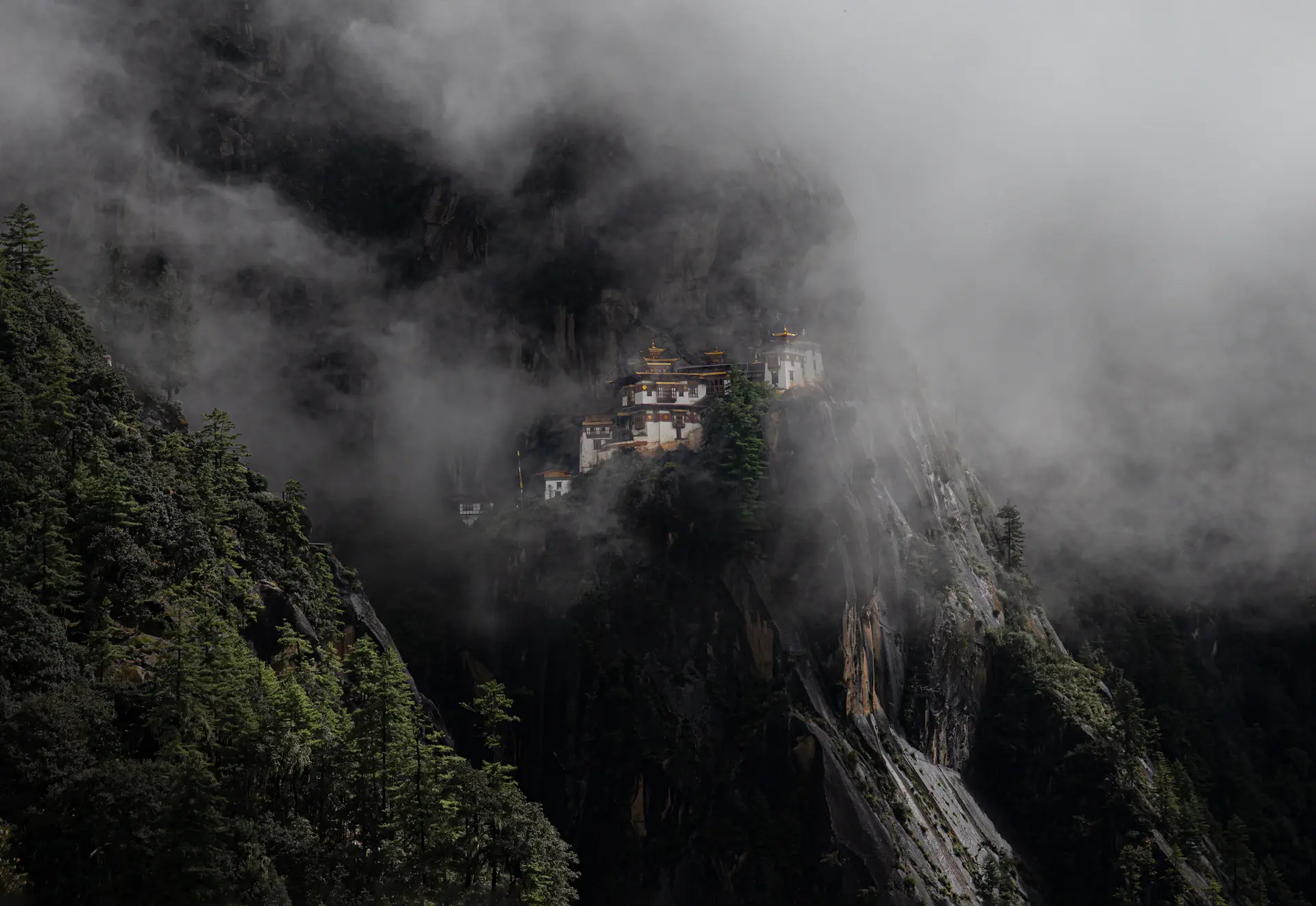 A cliffside monastery wreathed in Himalayan mist at dawn