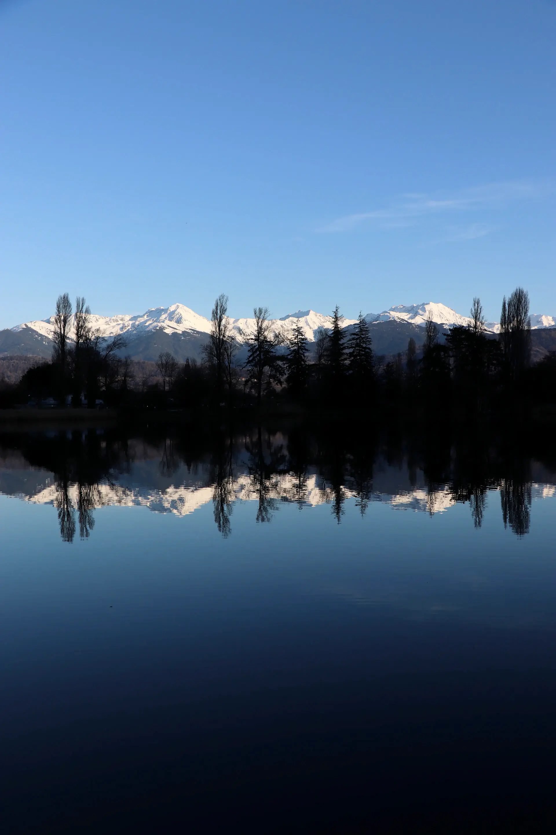 Snow peaks reflected in still water