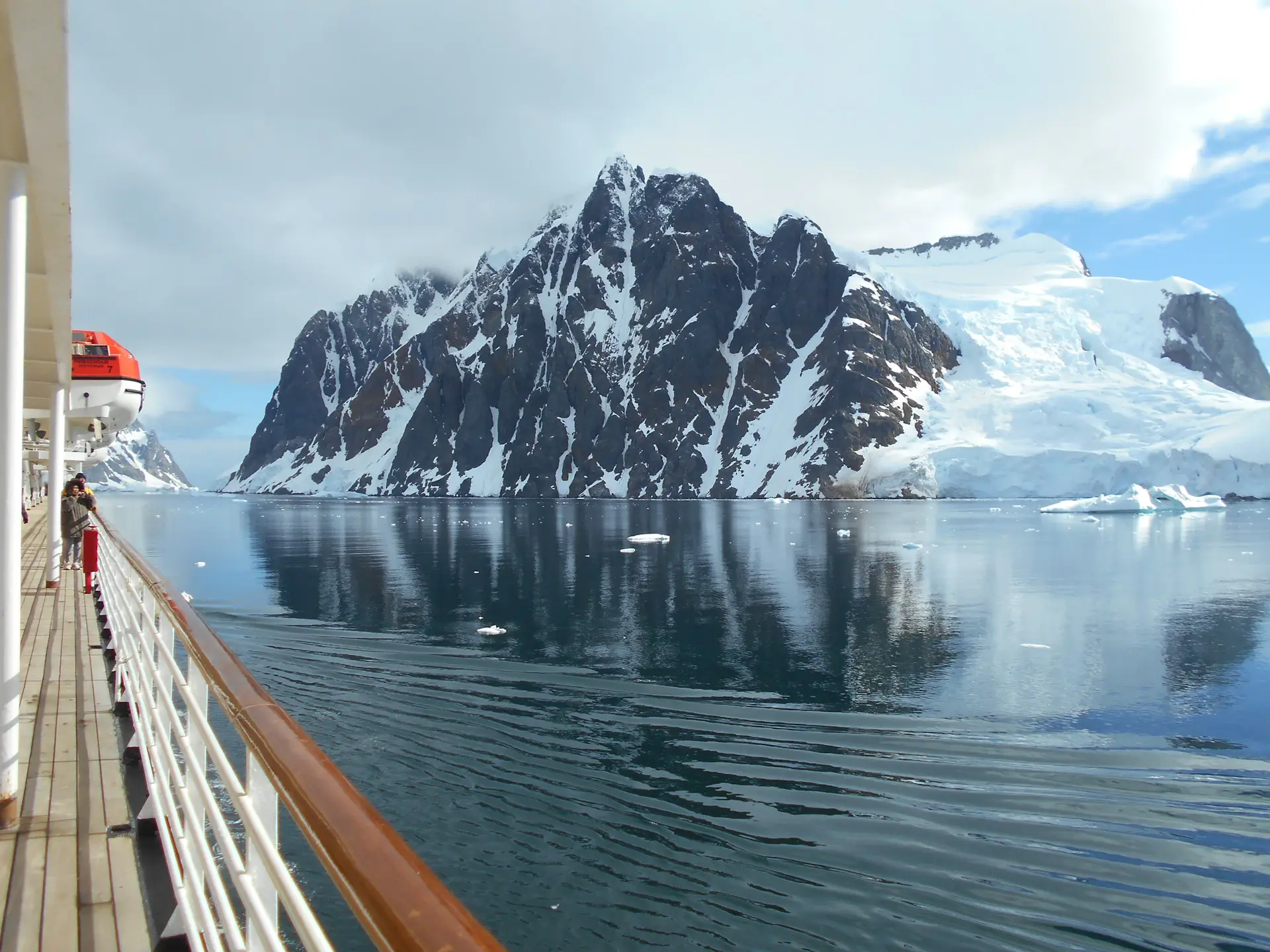 Expedition vessel anchored beside a vast glacier