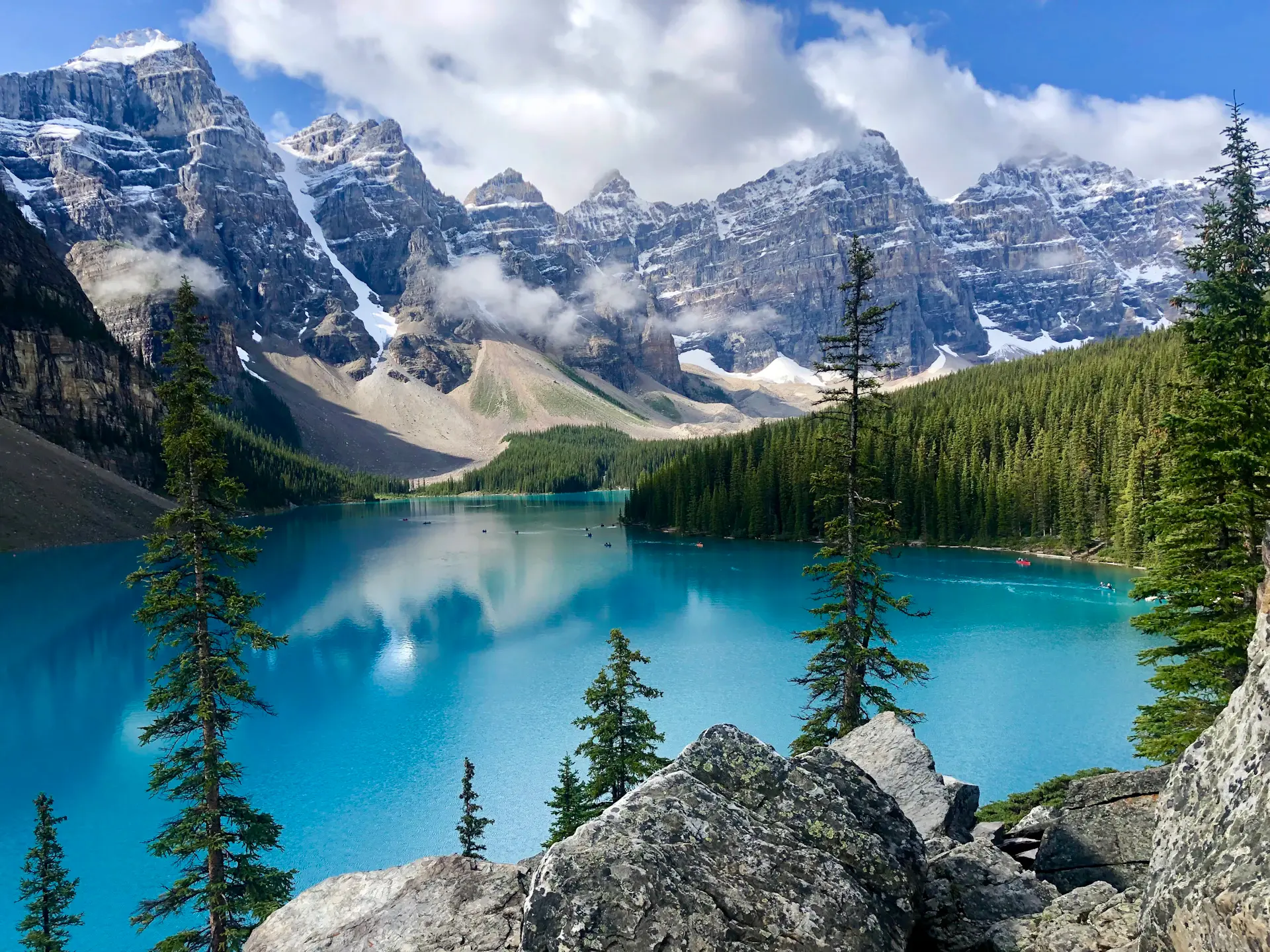 Turquoise glacial lake beneath snow-veined peaks