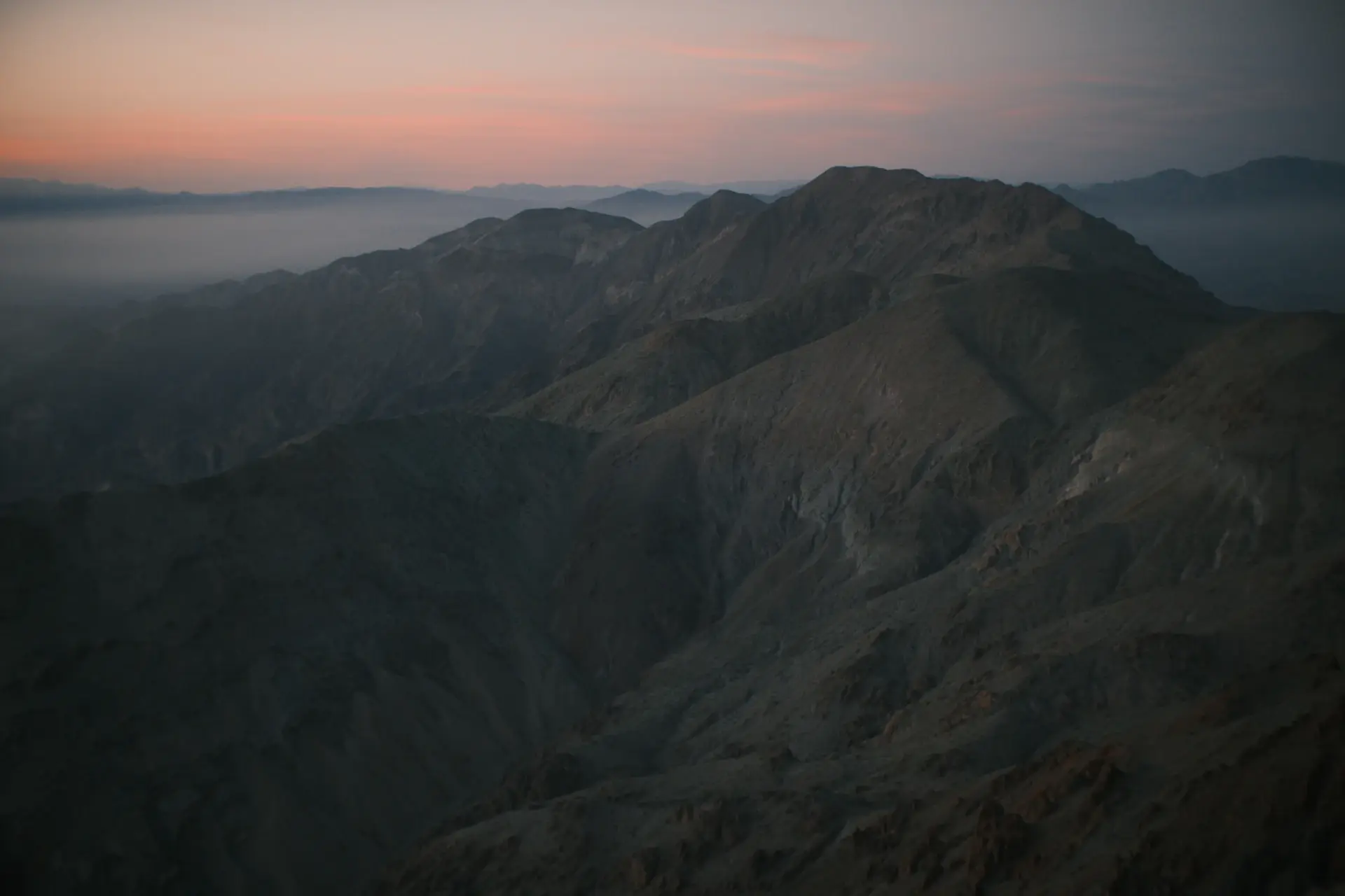 Dark, brooding mountain valley wrapped in low cloud
