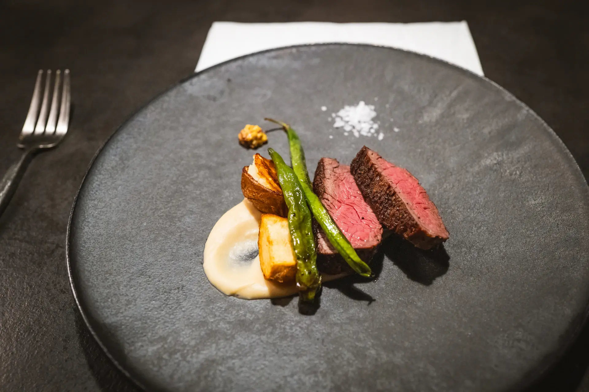 An intimately lit dining table set for a wine-led tasting menu