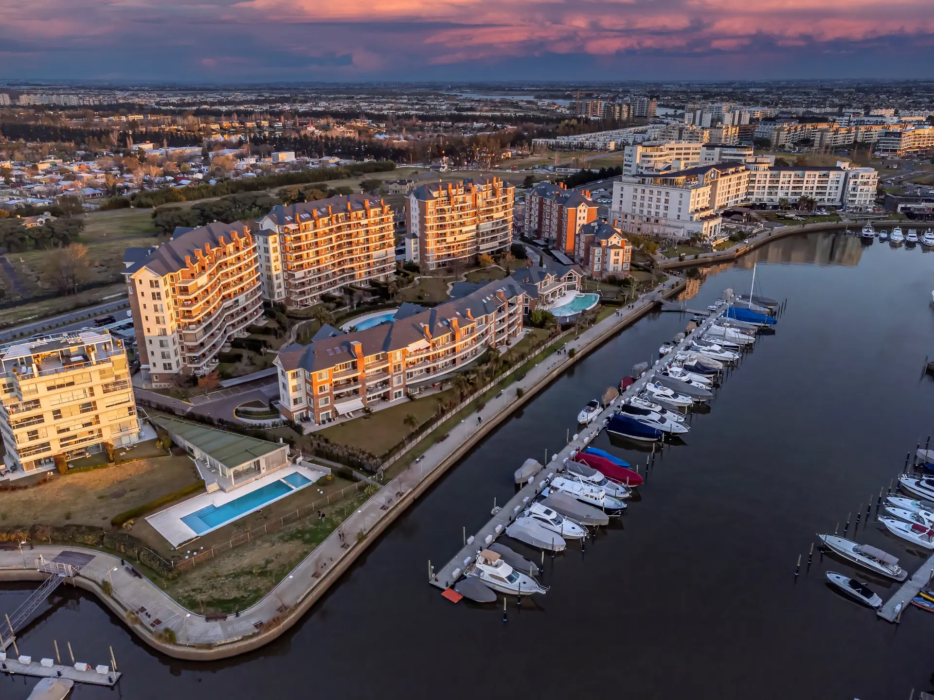 Waterfront luxury residences at dusk overlooking a calm marina