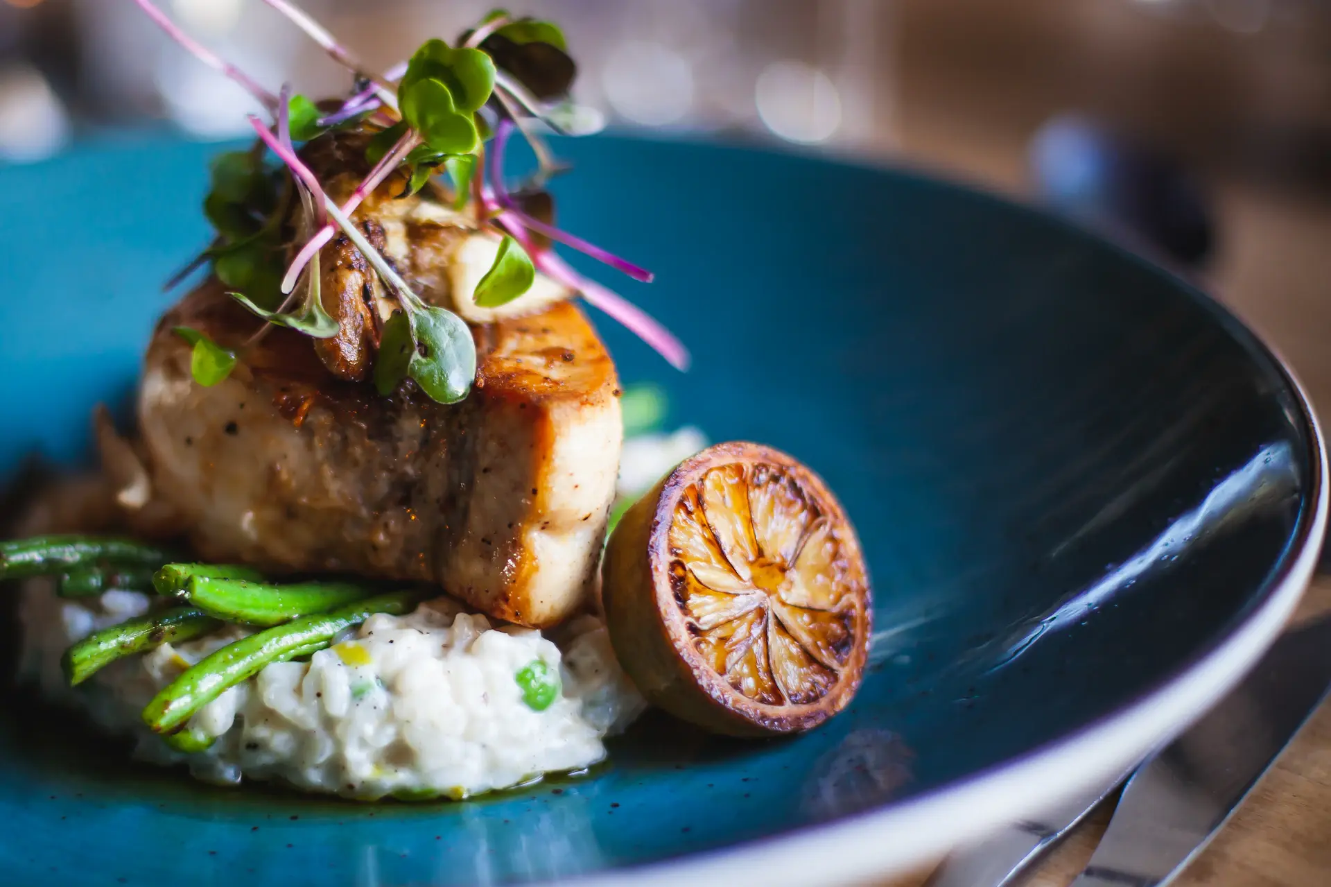Beautifully plated fine-dining course on an ivory table setting