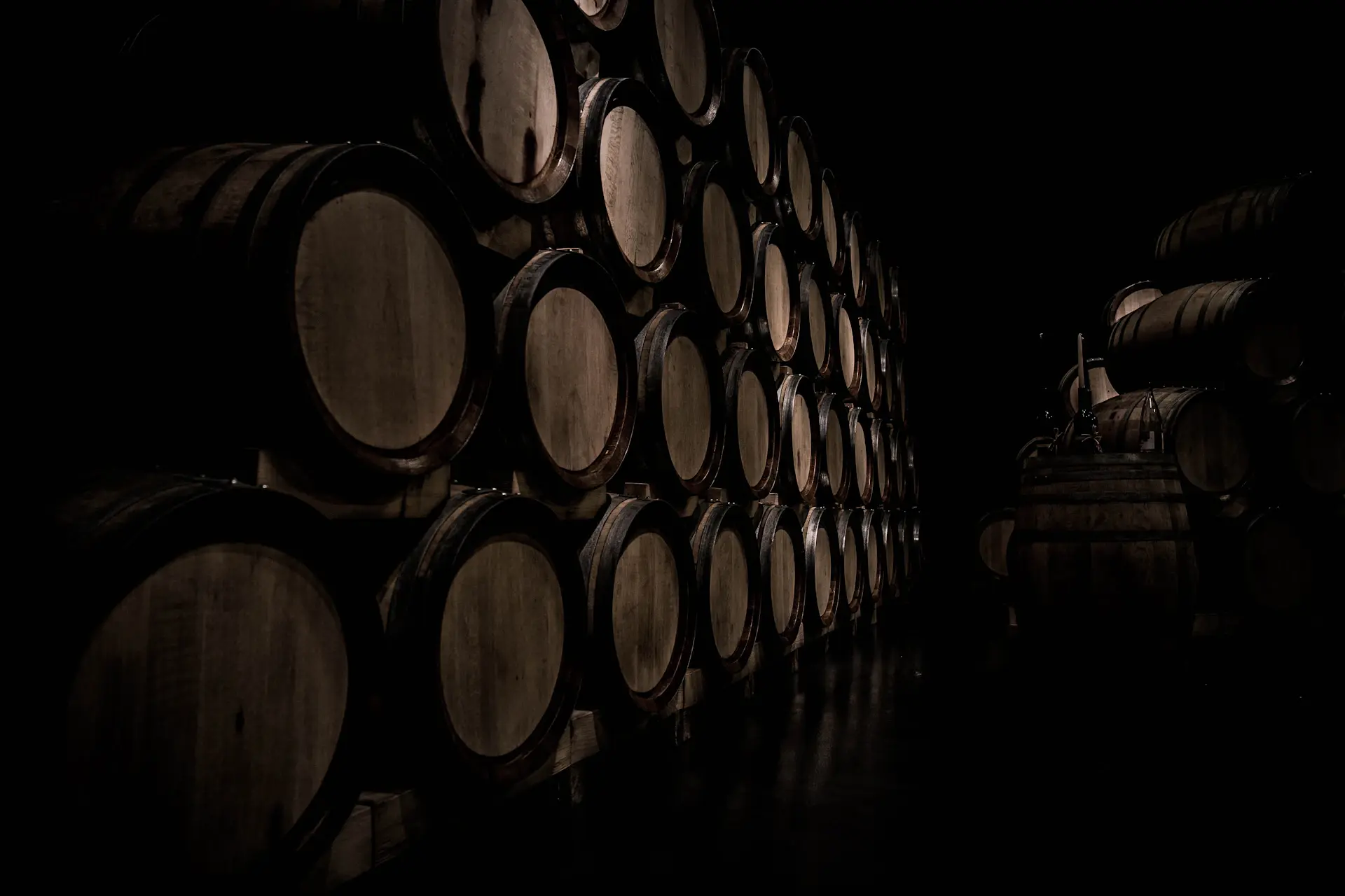 Aged barrels in a candle-lit heritage cellar