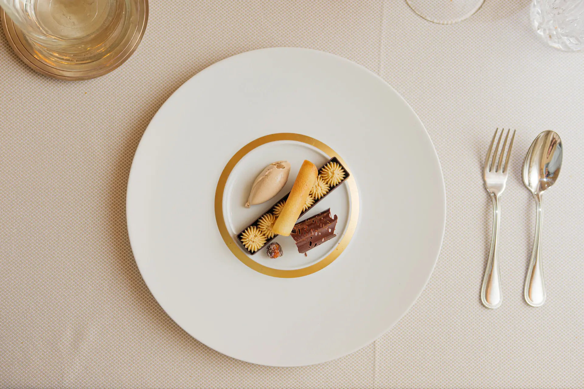 Fine-dining tasting course plated elegantly beside a flute of champagne