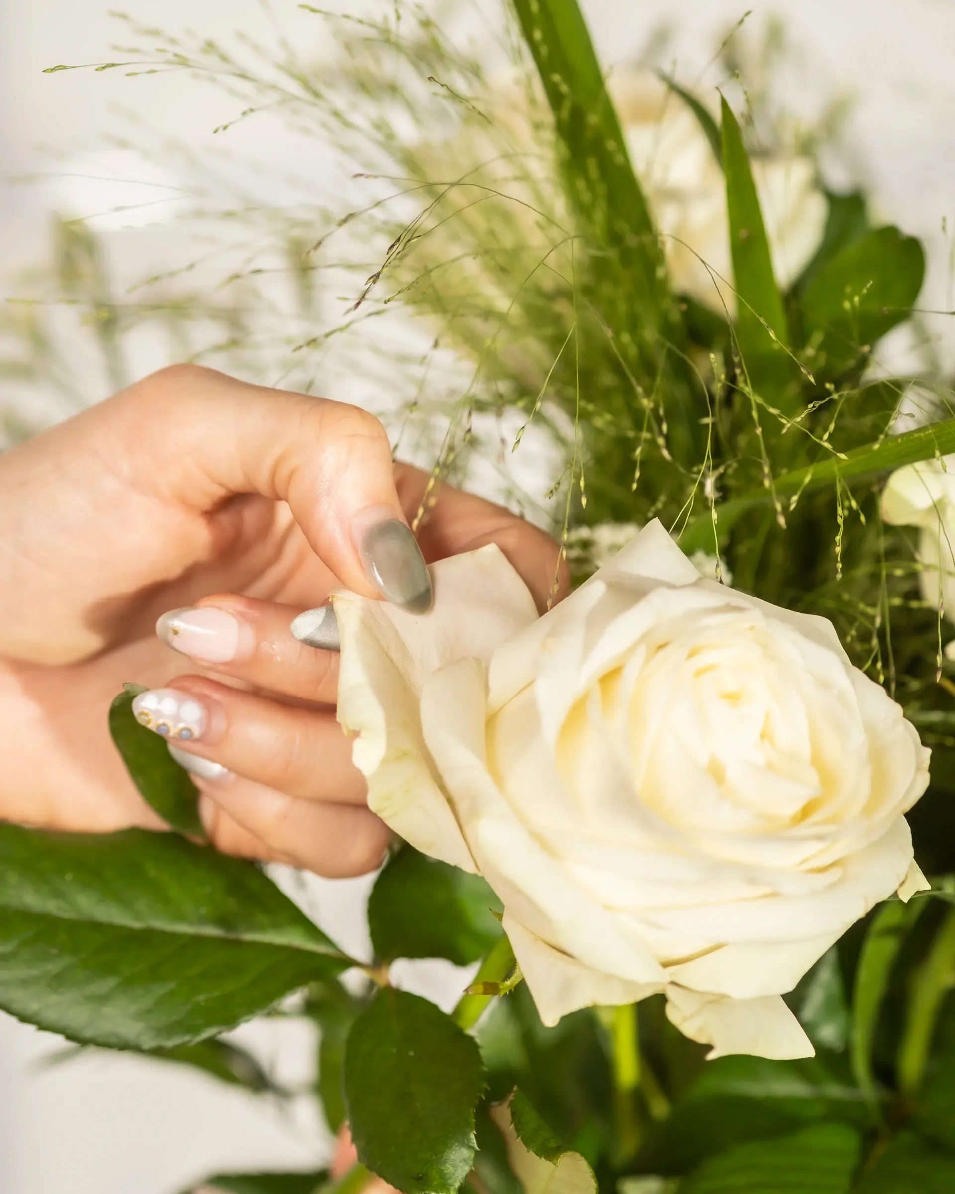 Florist's hands arranging a rose stem