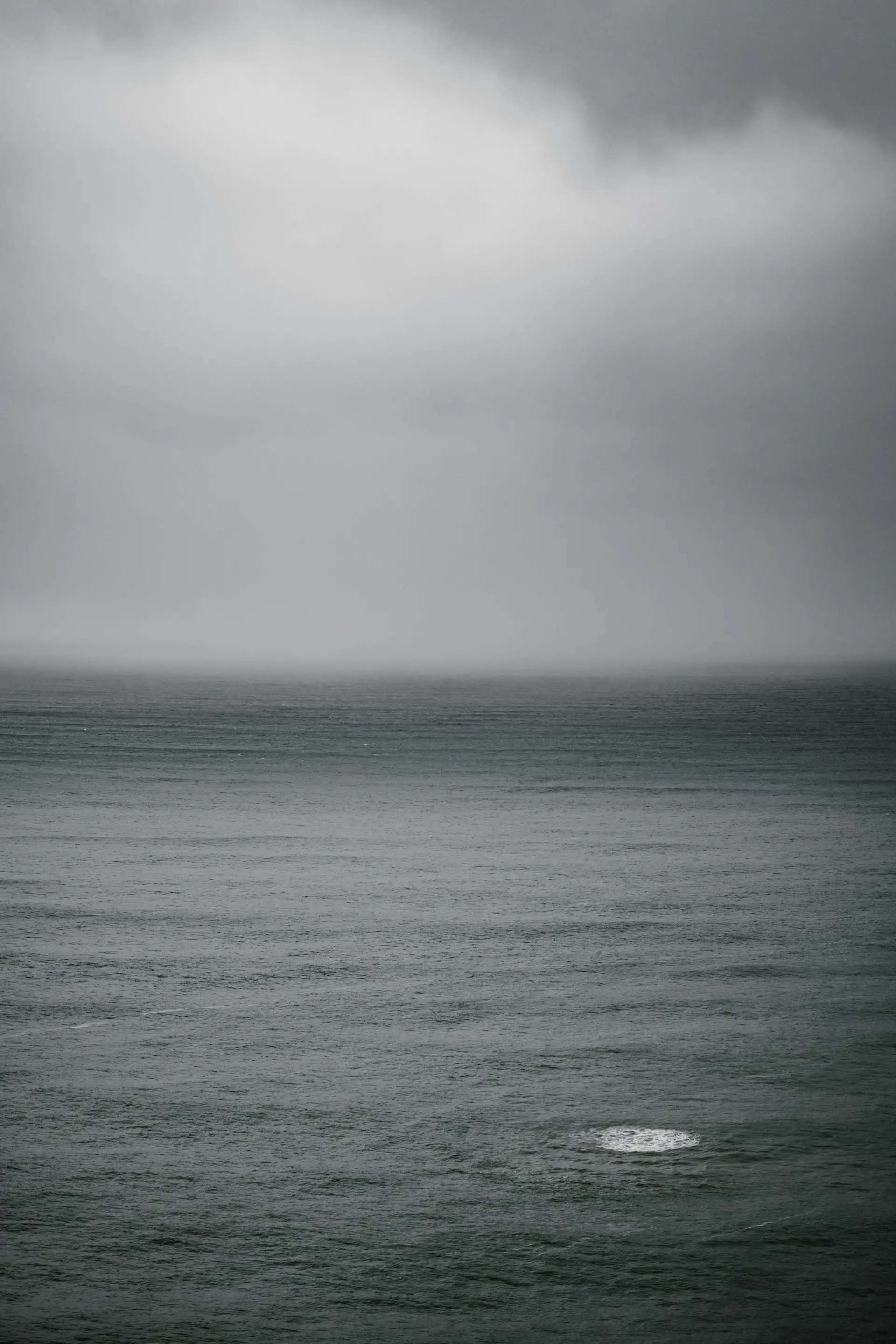 Dark storm clouds gathering over a restless grey sea