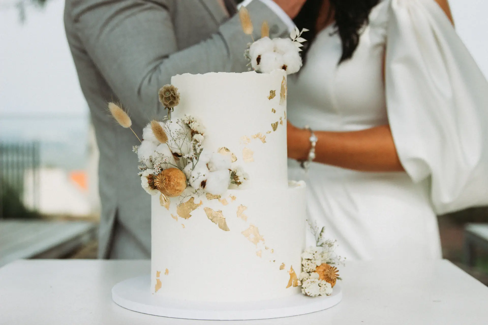 Wedding cake beneath warm chandelier glow