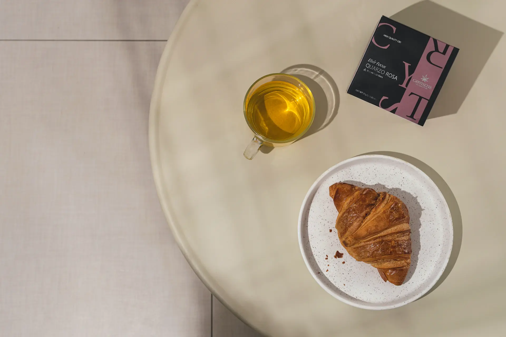 Line-art illustration of a cafe table set with coffee, croissant and a book