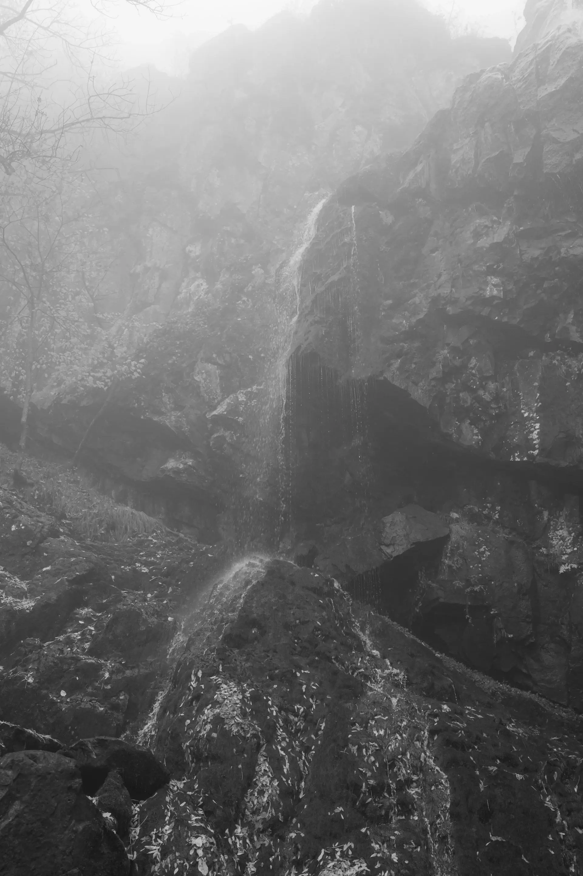 A tall stepped waterfall over mossy black rock
