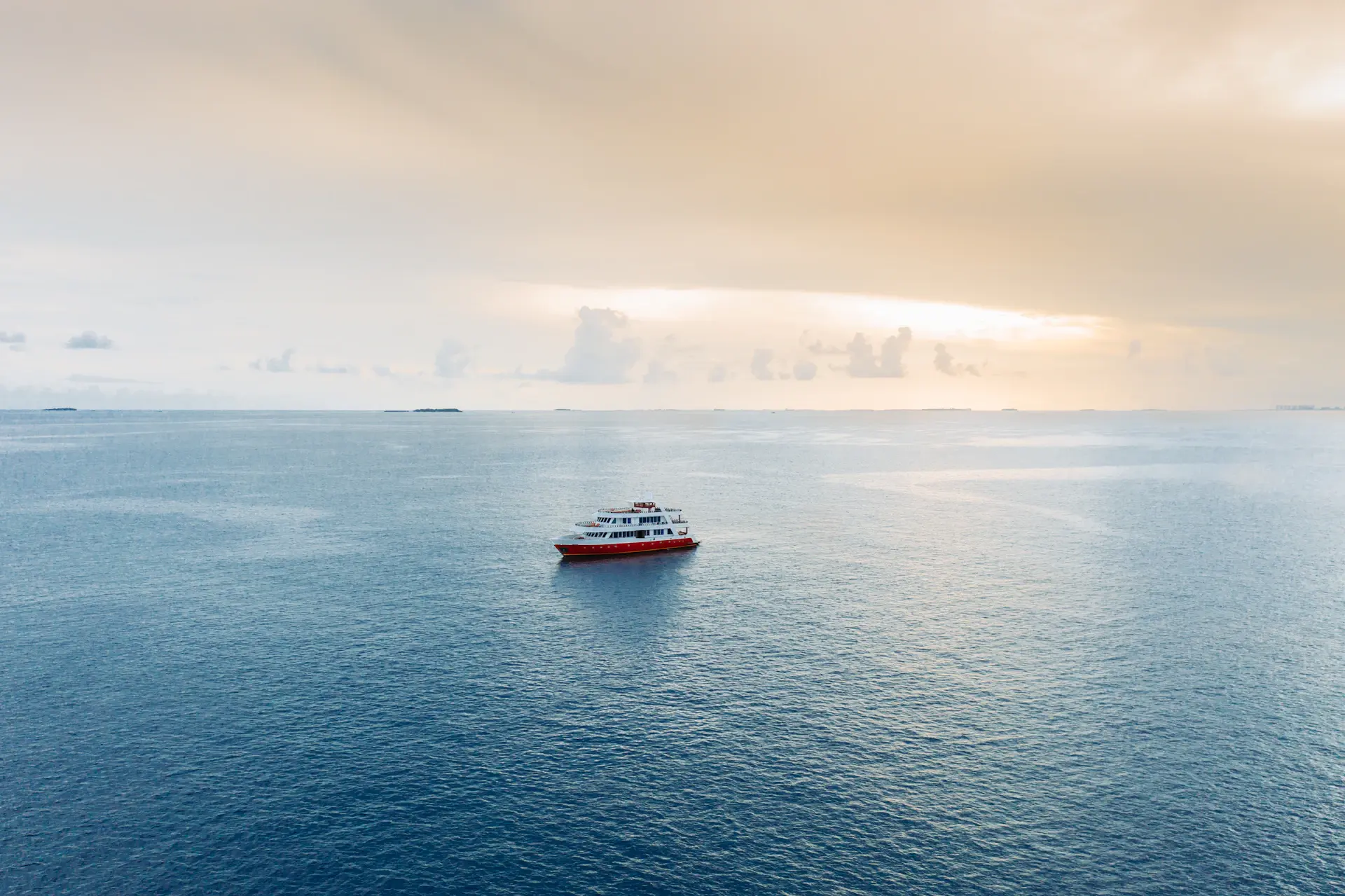 A lone vessel drifting through still polar waters at first light