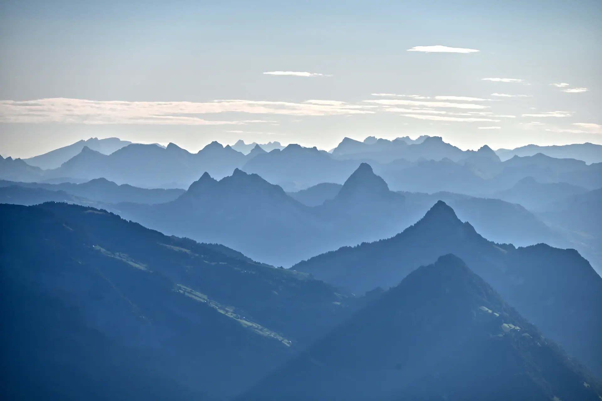 A long ridgeline fading into layered blue mountains at dusk